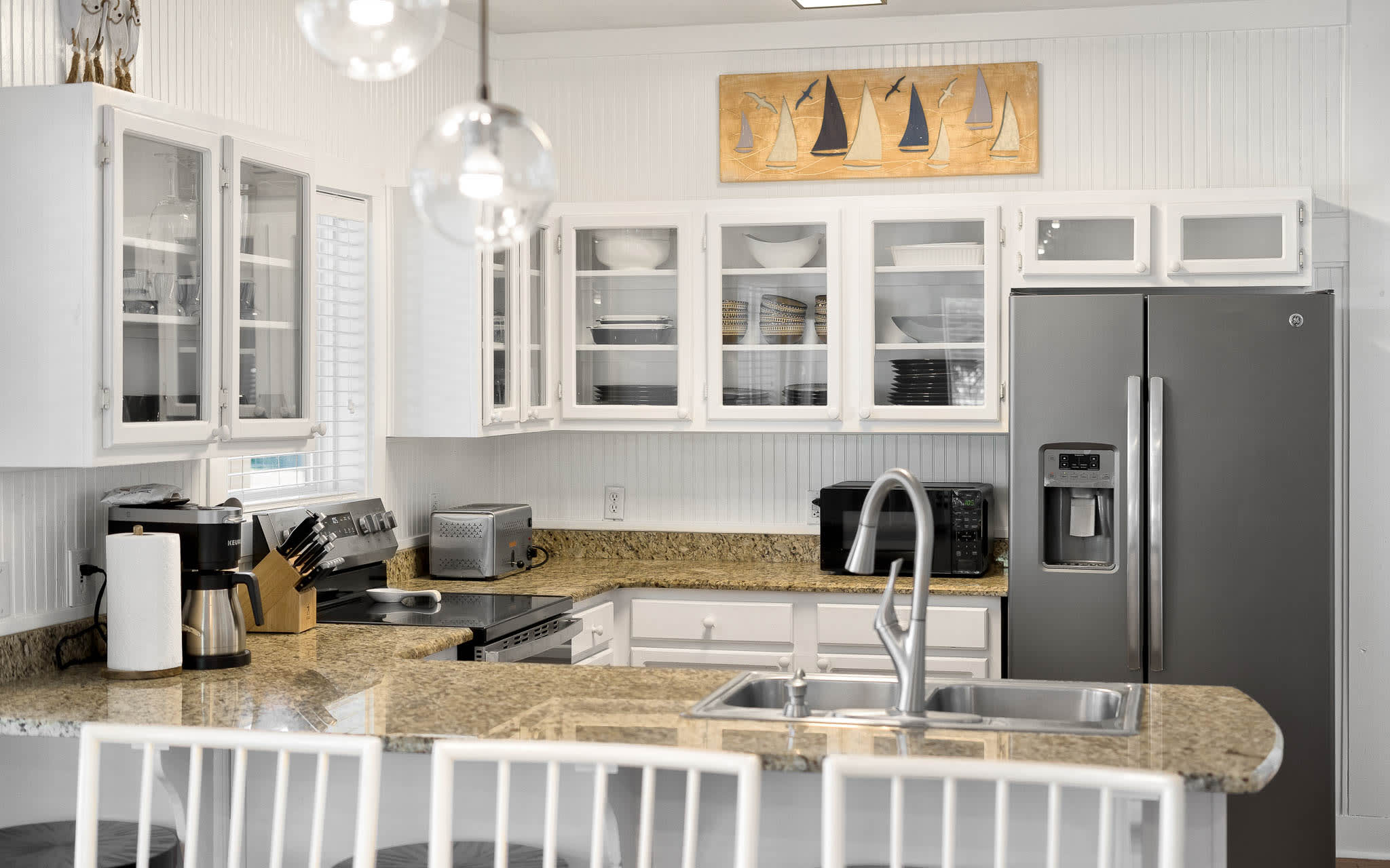 Your fully equipped kitchen features granite counters, modern appliances, and coastal charm - perfect for preparing meals during your getaway.