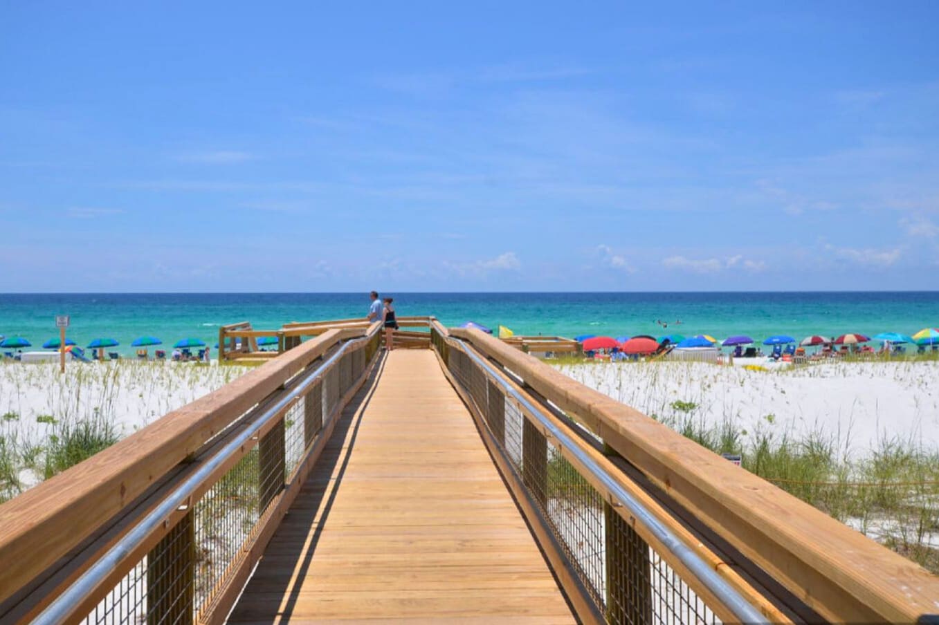 Scenic boardwalk at Sandpiper Cove Resort leading to a private, sugar-white sand beach with sweeping views of emerald Gulf waters and a relaxed, coastal atmosphere.