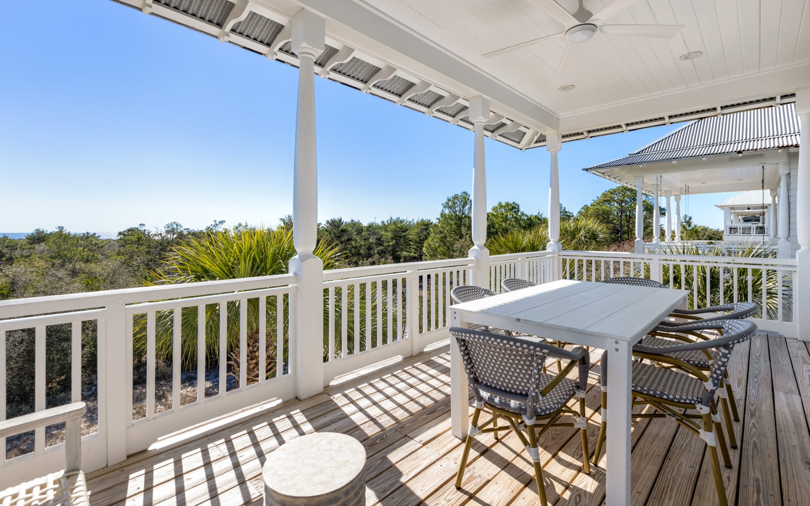 Relax on your private covered balcony with dining table, surrounded by lush tropical greenery and peaceful treetop views.