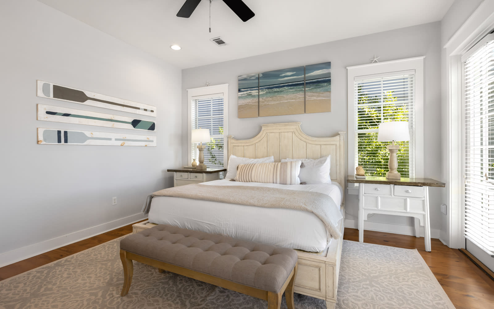 Drift into peaceful sleep in this serene bedroom with coastal artwork, plush bedding, and gentle natural light filtering through your windows.