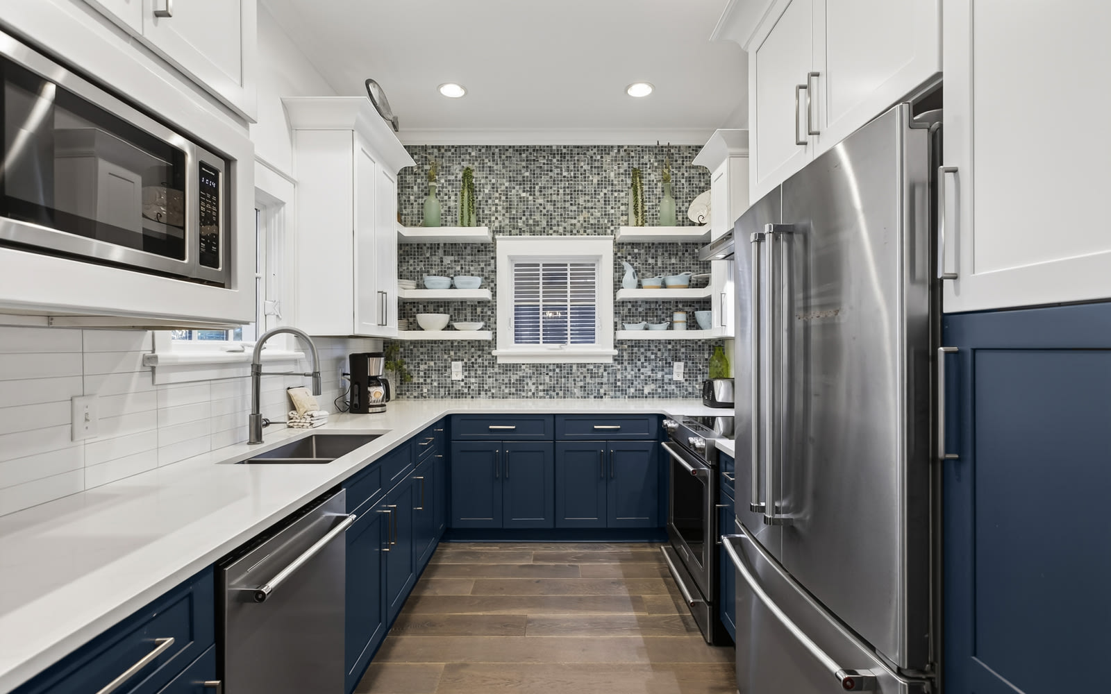 Your gourmet kitchen awaits with gleaming appliances, stylish blue cabinets, and spacious counters perfect for creating memorable meals.