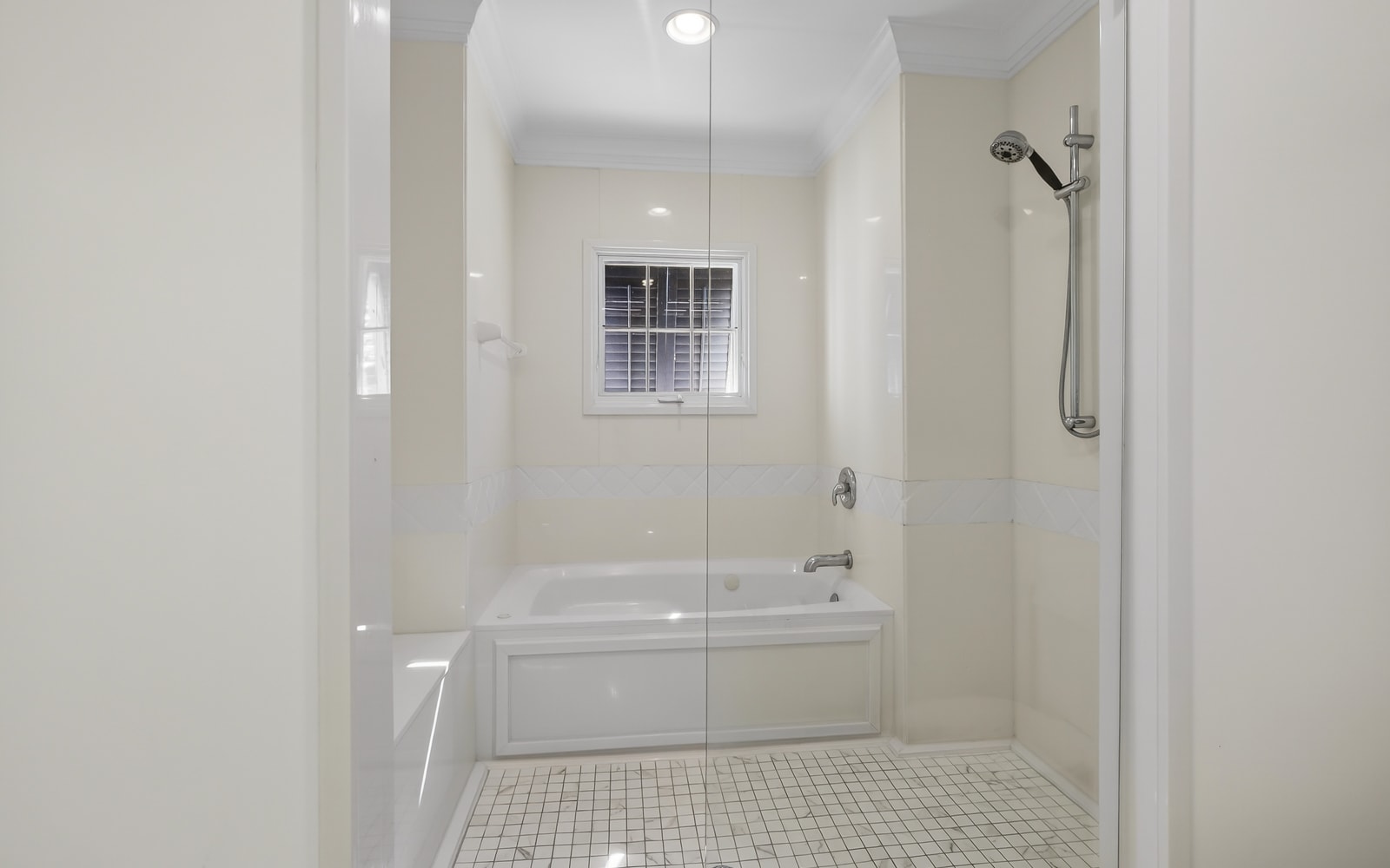 Your spacious bathroom features a luxurious soaking tub and walk-in shower with gleaming white marble surrounds.