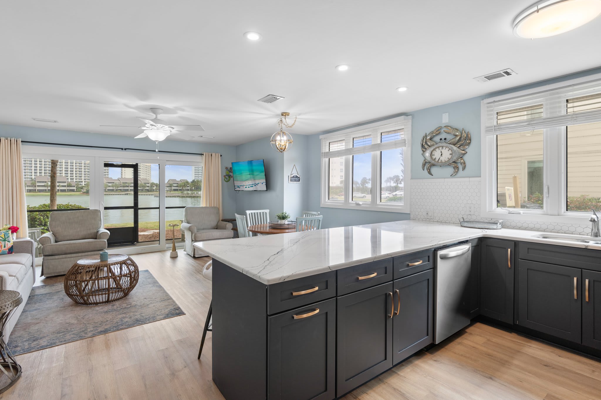 Spacious open layout with quartz countertops, navy cabinets, and lake views from the kitchen—perfect for entertaining and relaxing in style.