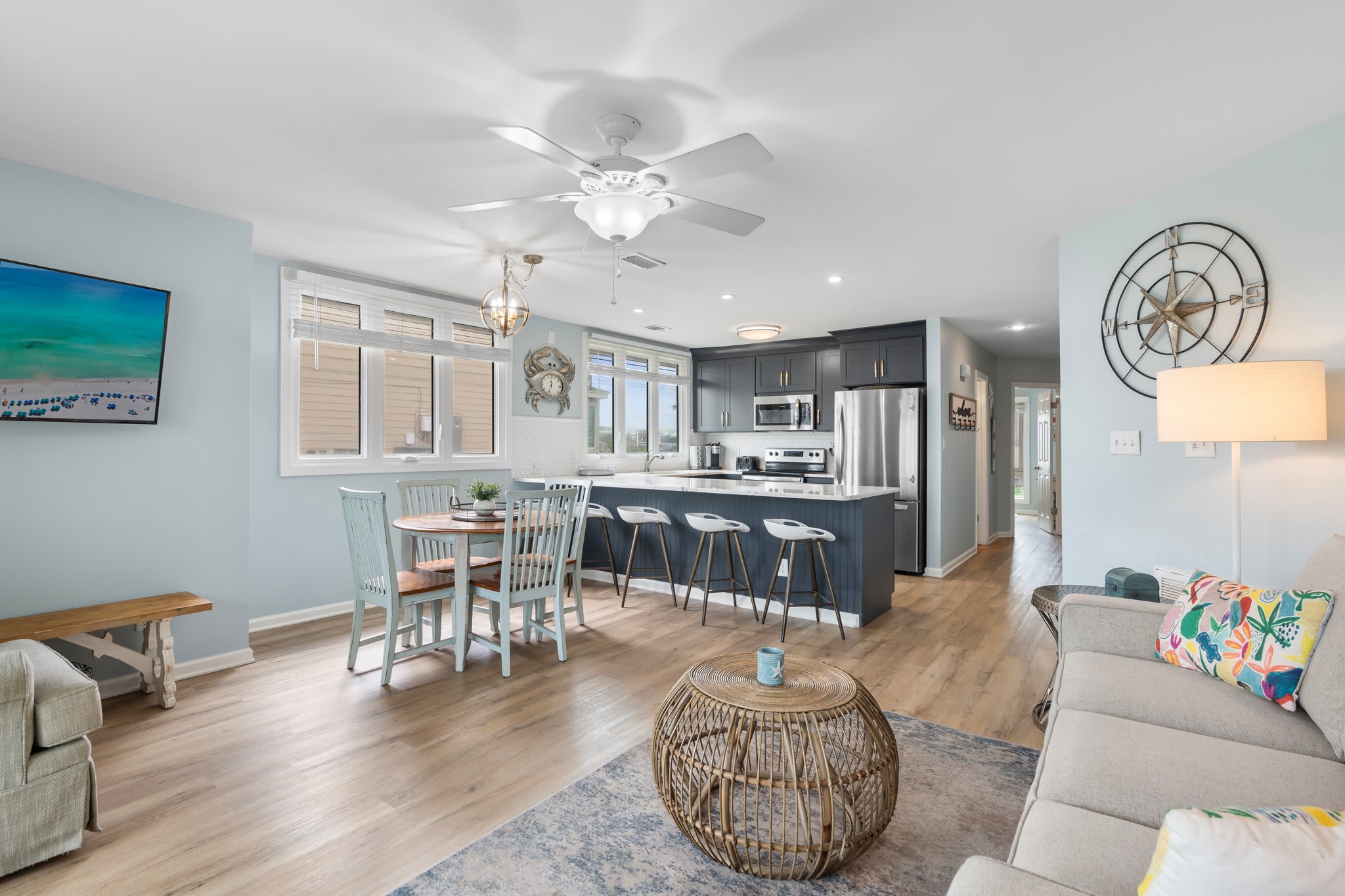 Spacious open layout with coastal charm, featuring a full kitchen, bar seating, dining table for four, and a cozy living area—perfect for relaxing and entertaining by the lake.