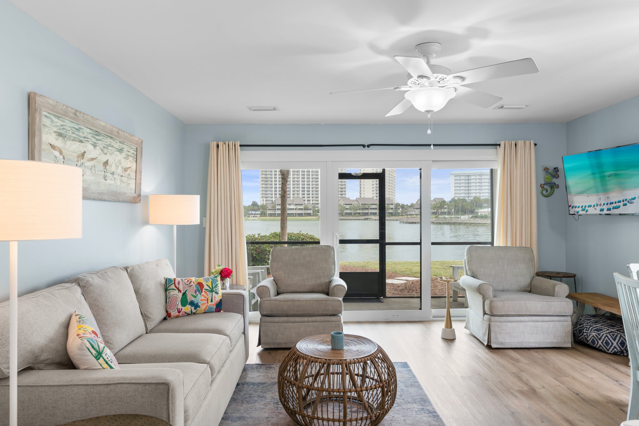 Relax in the stylish living room with lake views, plush seating, and natural light pouring through sliding glass doors that open to a screened patio.