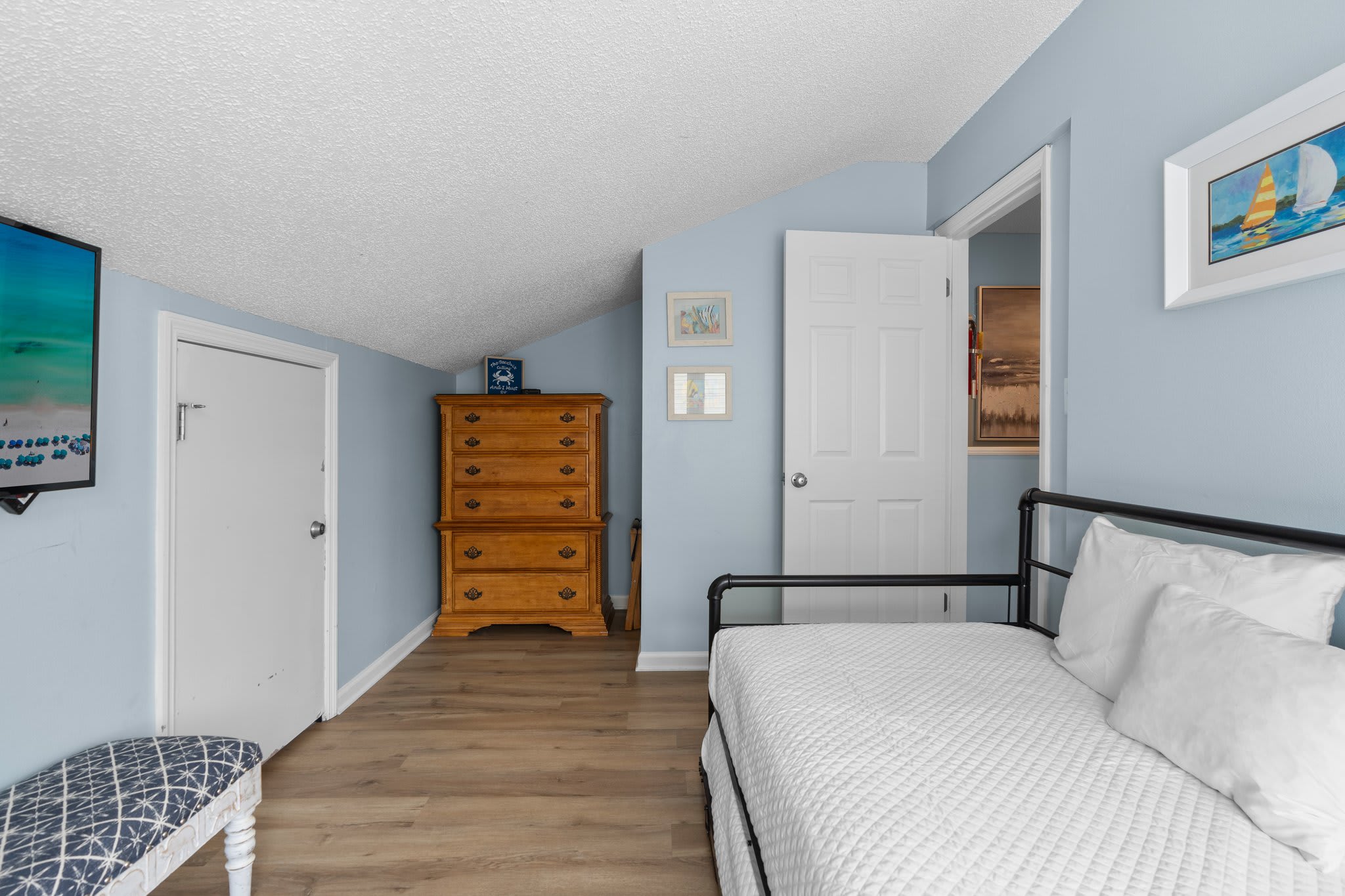 This versatile guest loft features a cozy daybed that converts to a king, wood flooring, and a classic chest of drawers—ideal for kids or extra guests.