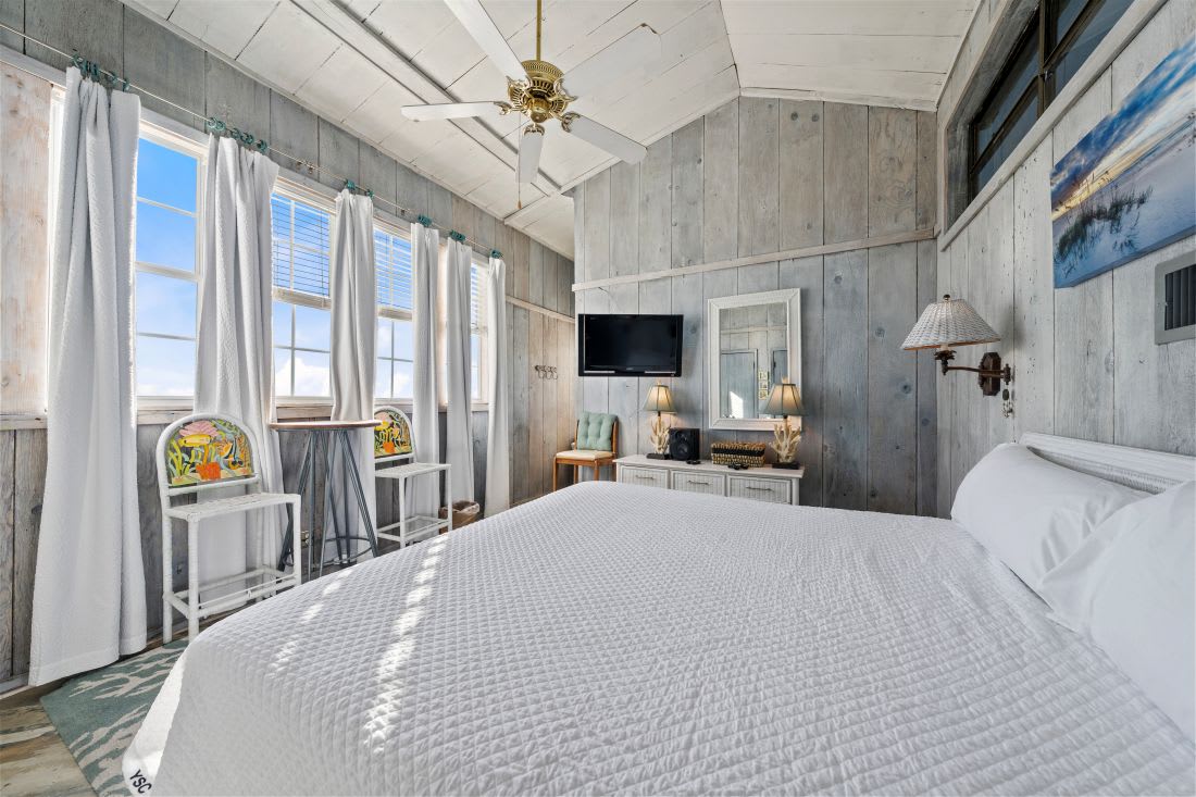 Rest peacefully in your charming beach cottage bedroom, where weathered wood walls and ocean breezes create the perfect coastal retreat.