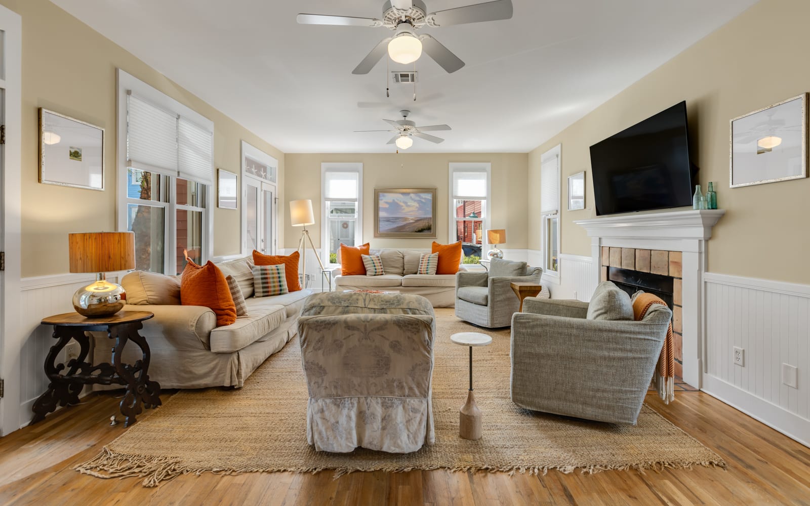 Settle into this bright living room where soft gray sofas and pops of orange create the perfect spot for relaxation.