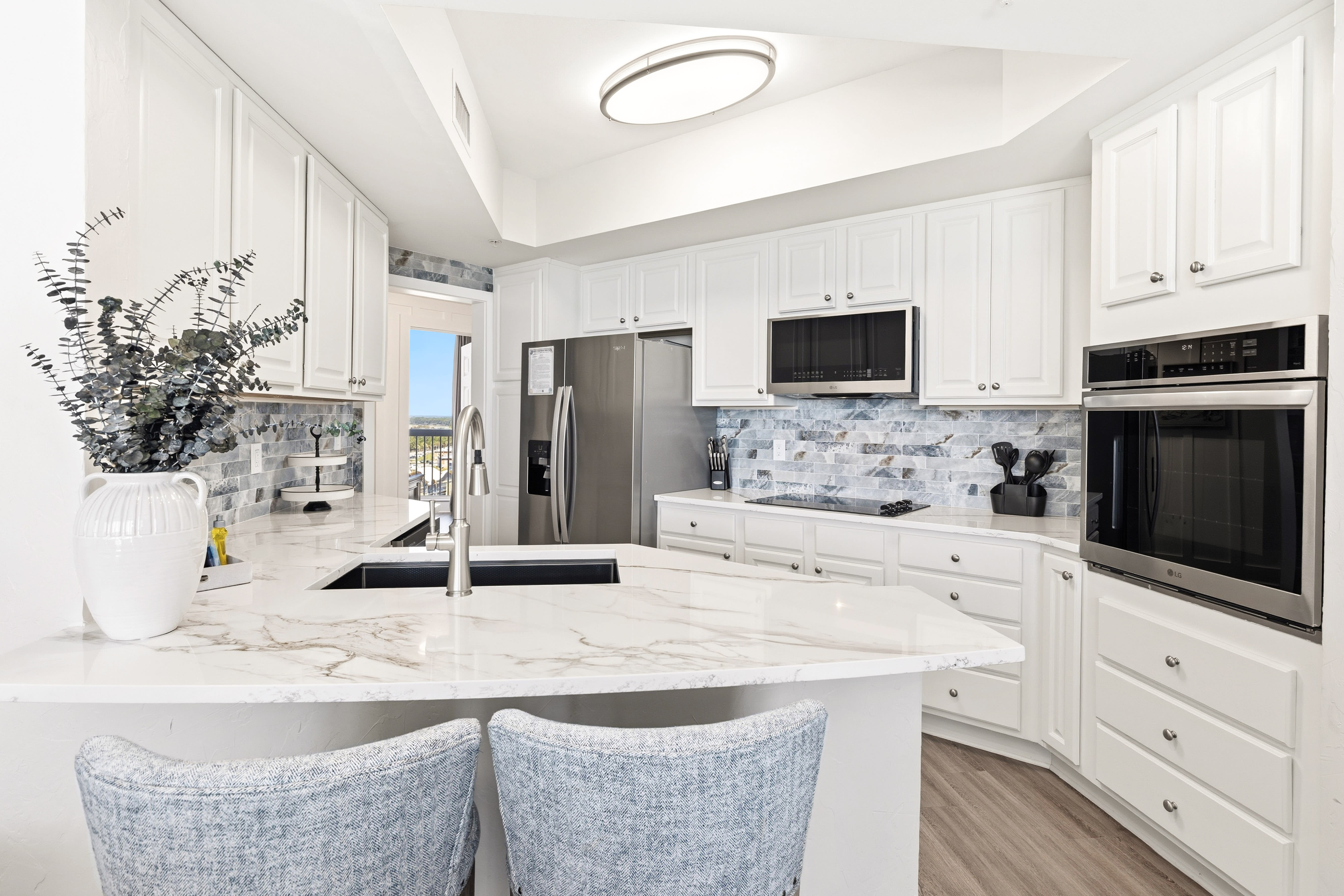 Your gourmet kitchen awaits with gleaming marble counters, premium appliances, and elegant white cabinetry—perfect for creating memorable meals during your stay.