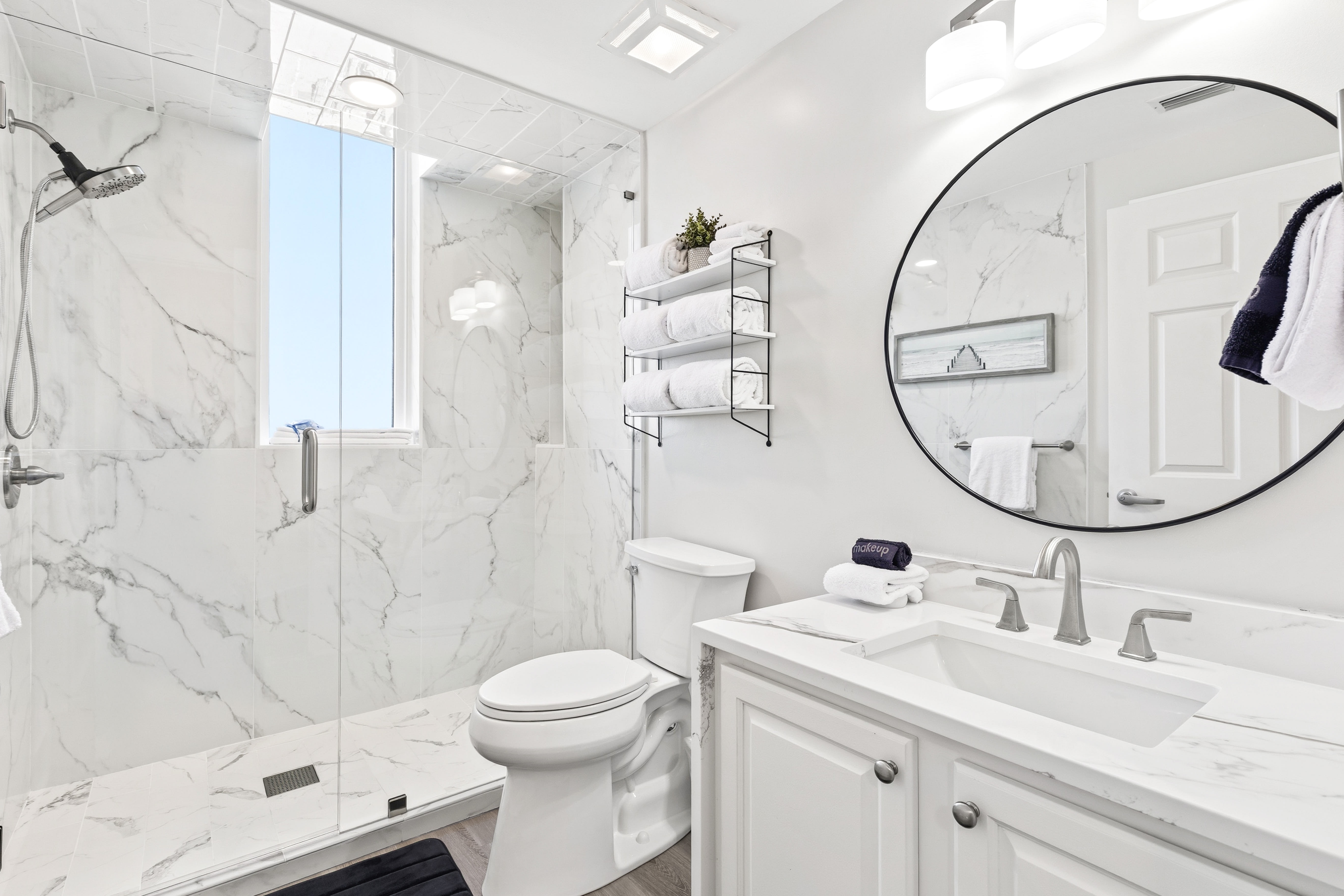 Step into your private marble sanctuary featuring a spacious walk-in shower and elegant vanity, where luxury meets comfort.