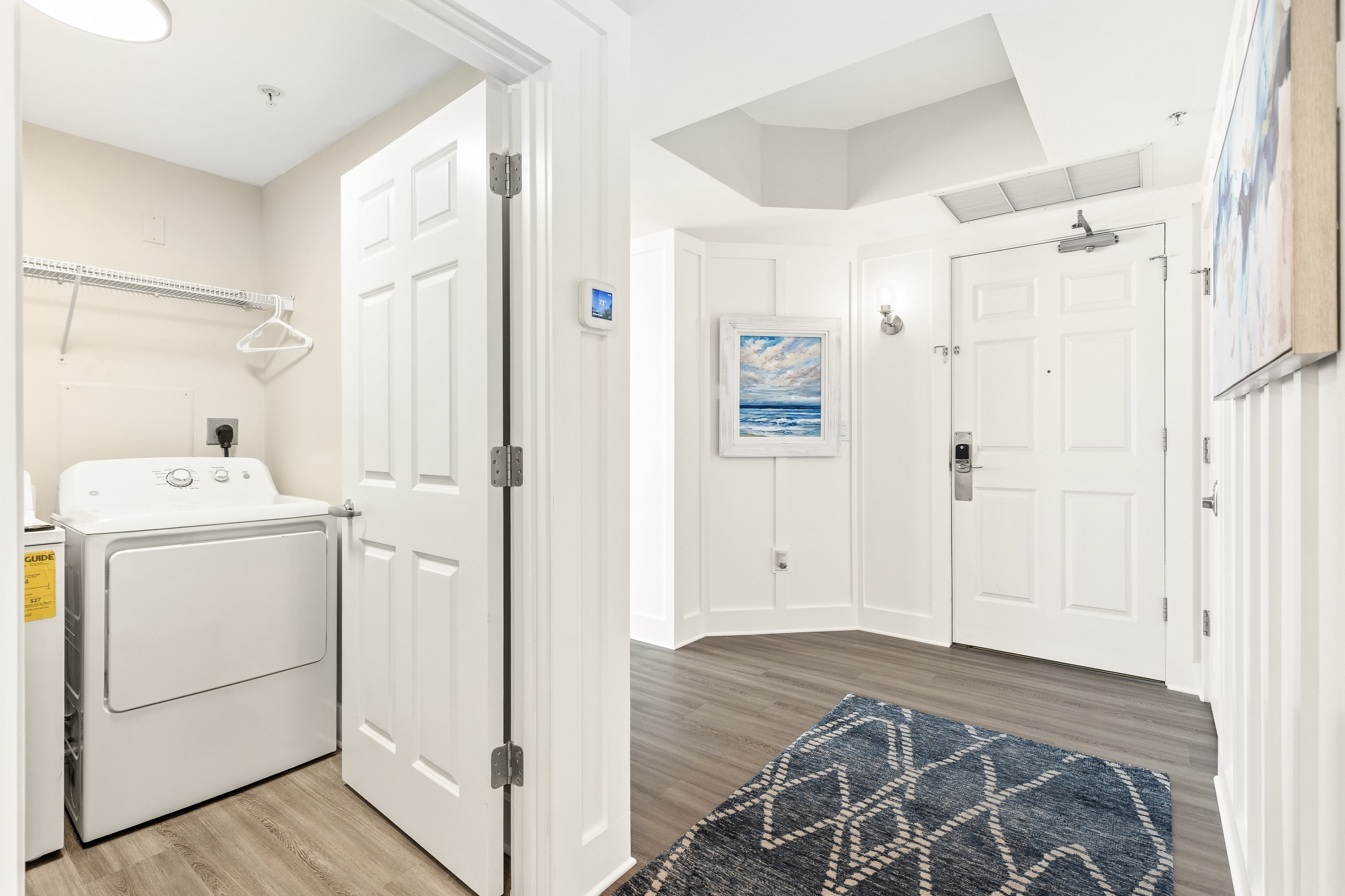 Step inside your welcoming entrance where coastal artwork and modern touches create instant comfort, with convenient in-unit laundry just steps away.