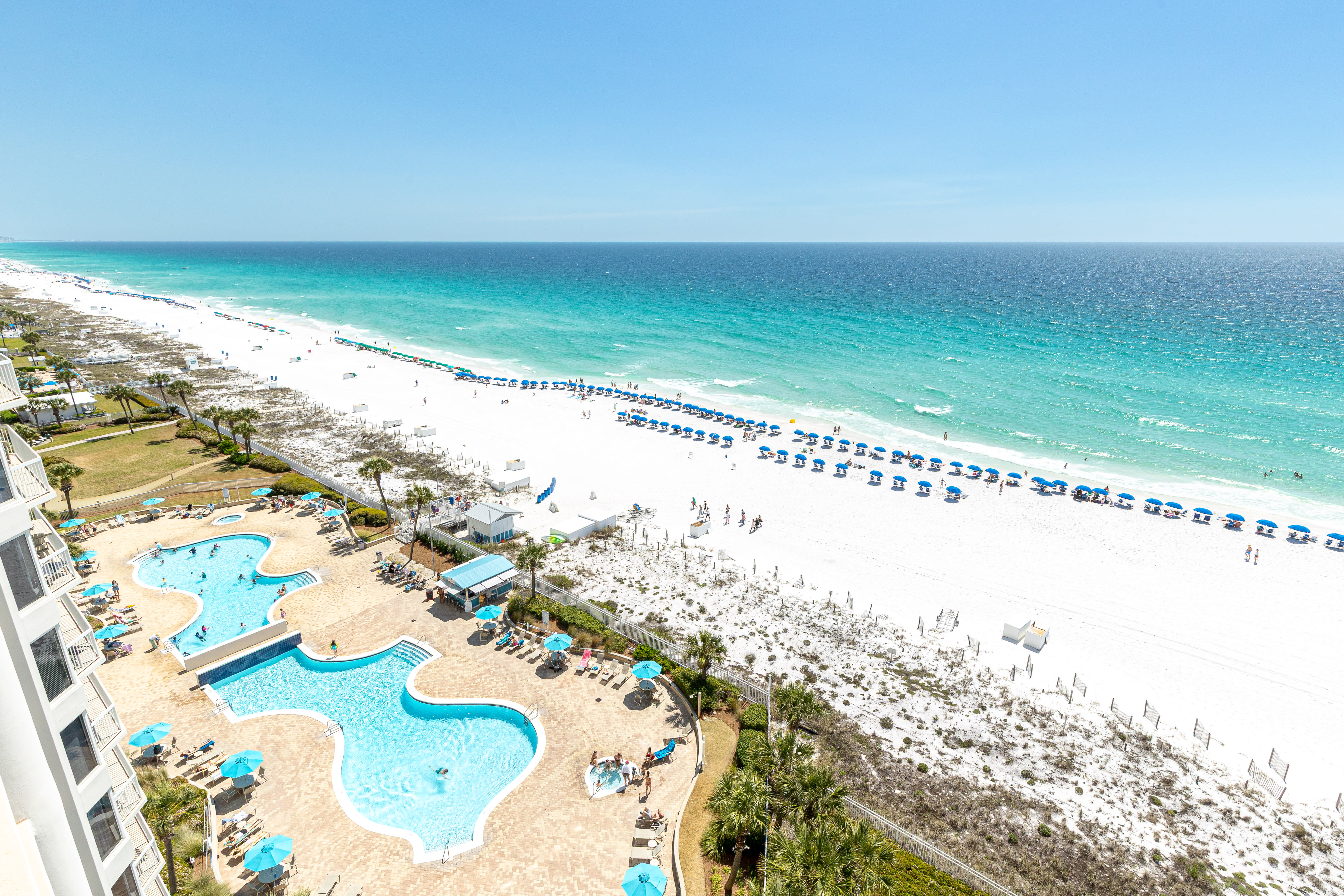 Stunning beachfront resort featuring expansive pools and pristine white sand beach with crystal-clear turquoise waters.