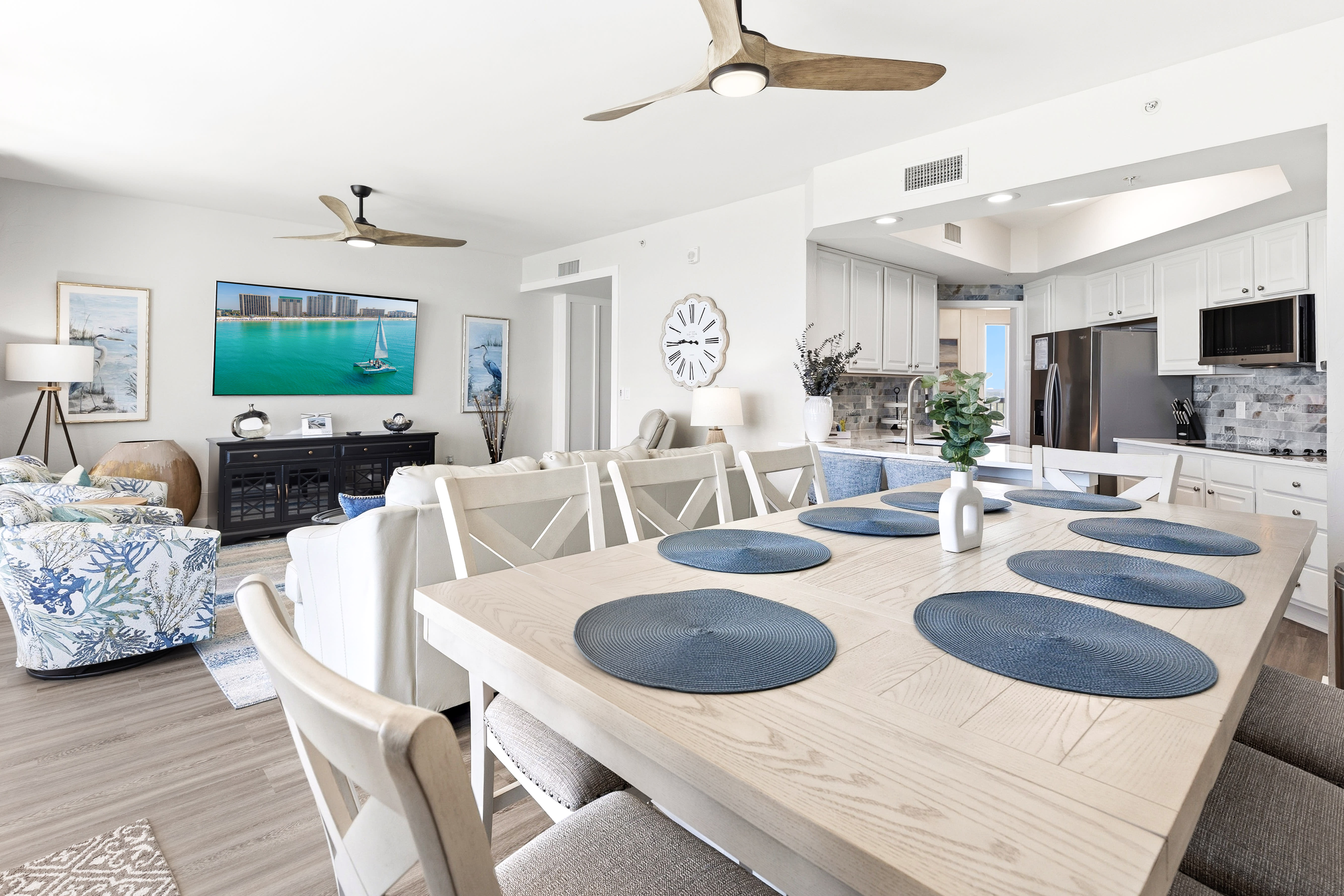 Your open-plan living space blends coastal charm with modern comfort, featuring a fully equipped kitchen and dining area perfect for memorable meals.