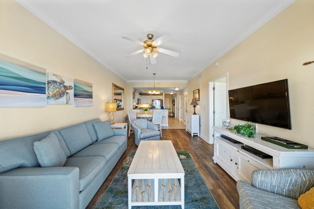 Unwind in your coastal-themed living room with plush seating, warm hardwood floors, and modern entertainment center for perfect relaxation.
