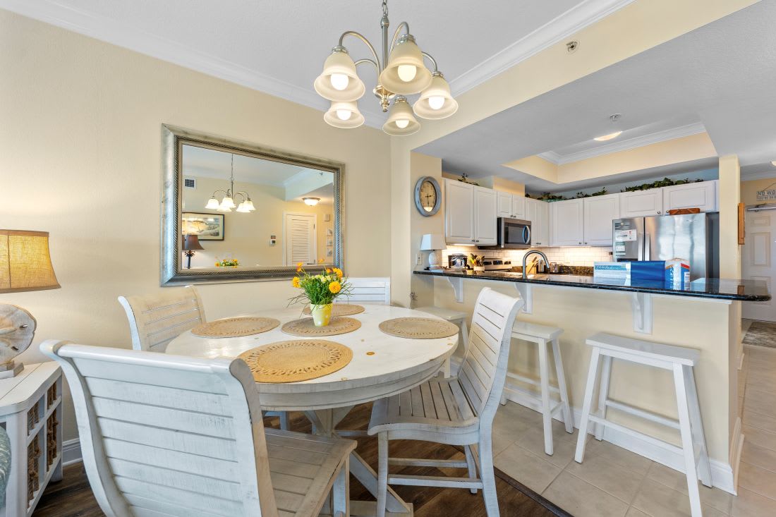 Gather around your elegant dining table for memorable meals, with a fully-equipped kitchen just steps away for easy entertaining and coastal living.