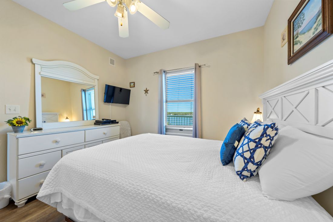 Drift off in your cozy bedroom featuring crisp white linens, nautical touches, and a peaceful water view from your window.