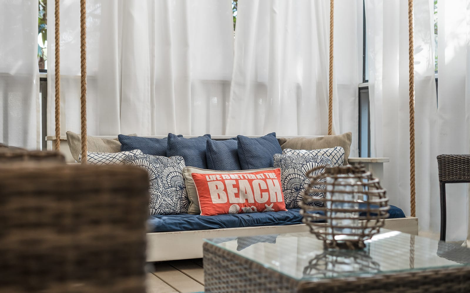 Unwind on your private swing daybed, draped in flowing curtains with coastal-inspired pillows creating the perfect beachside retreat.