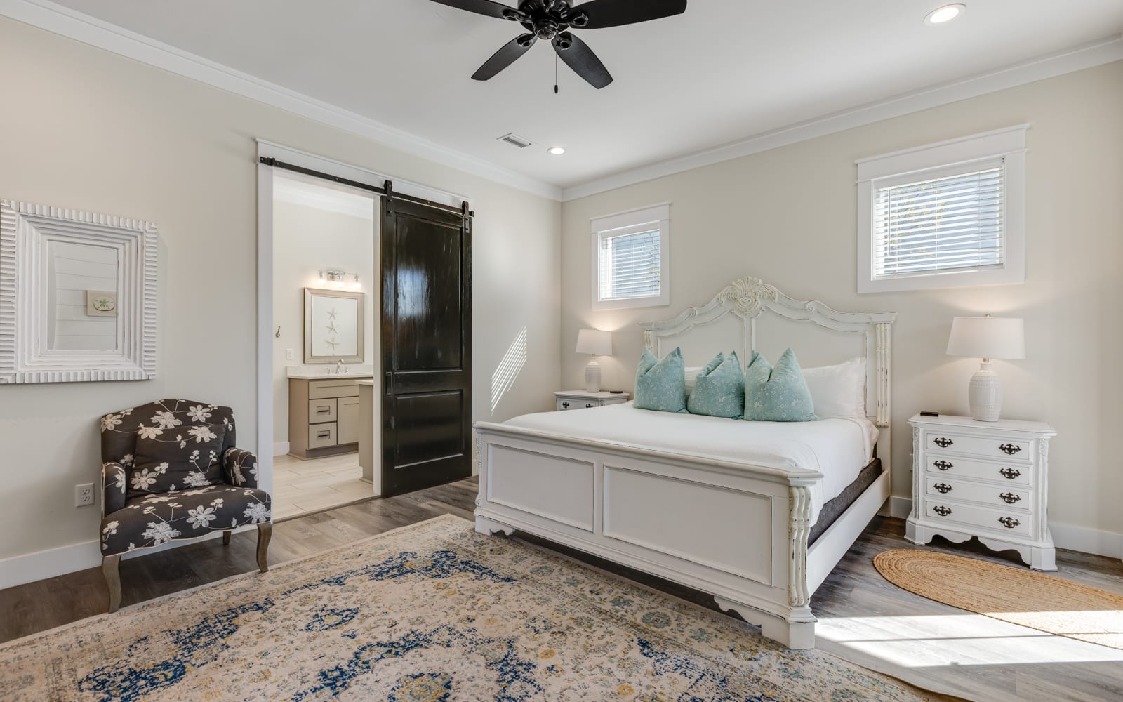 Your elegant bedroom sanctuary features plush bedding, antique-style furnishings, and a charming barn door leading to your private ensuite.