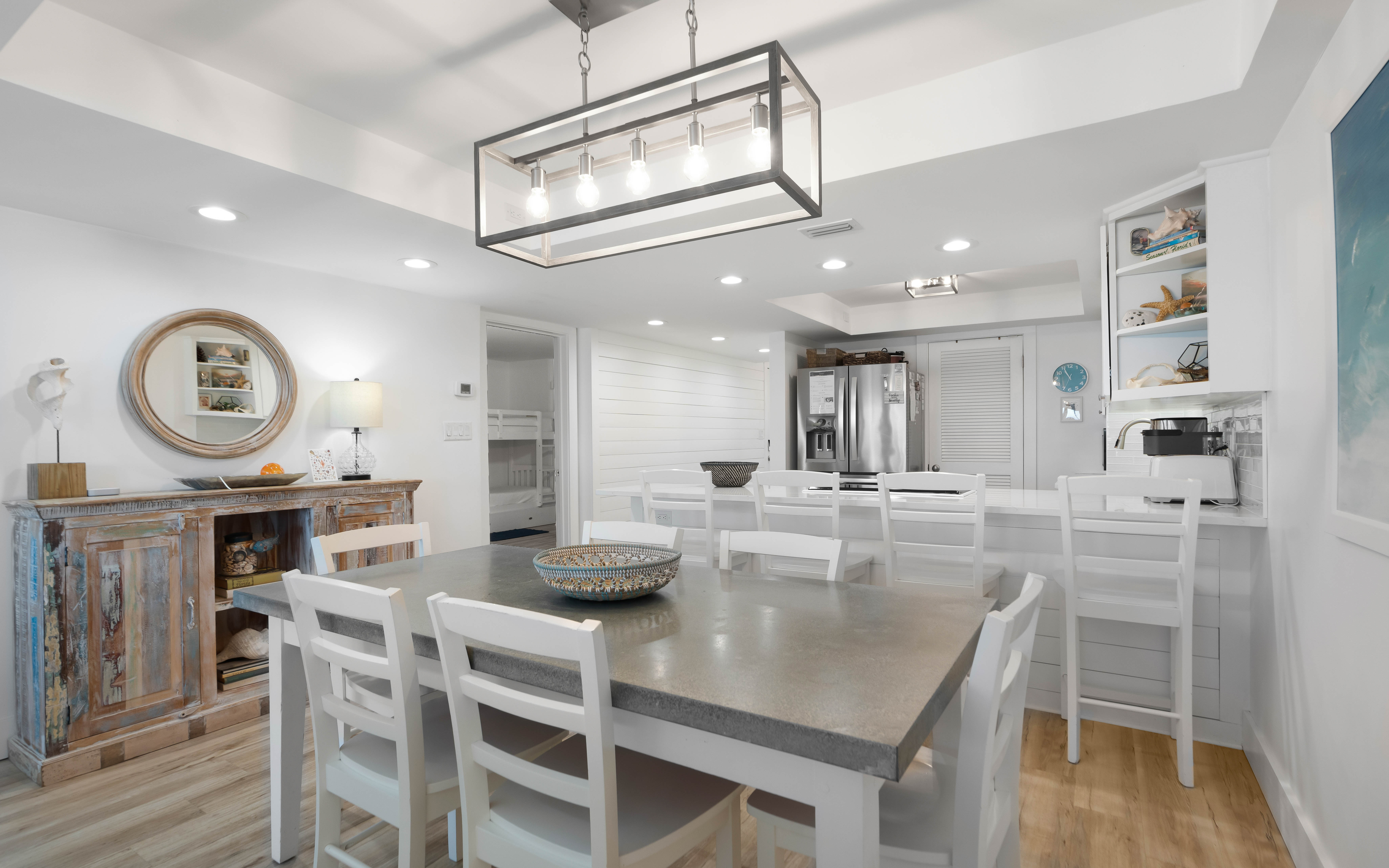 Gather with loved ones in your open-concept kitchen and dining area, where bright white finishes and elegant lighting create the perfect backdrop for memorable meals.