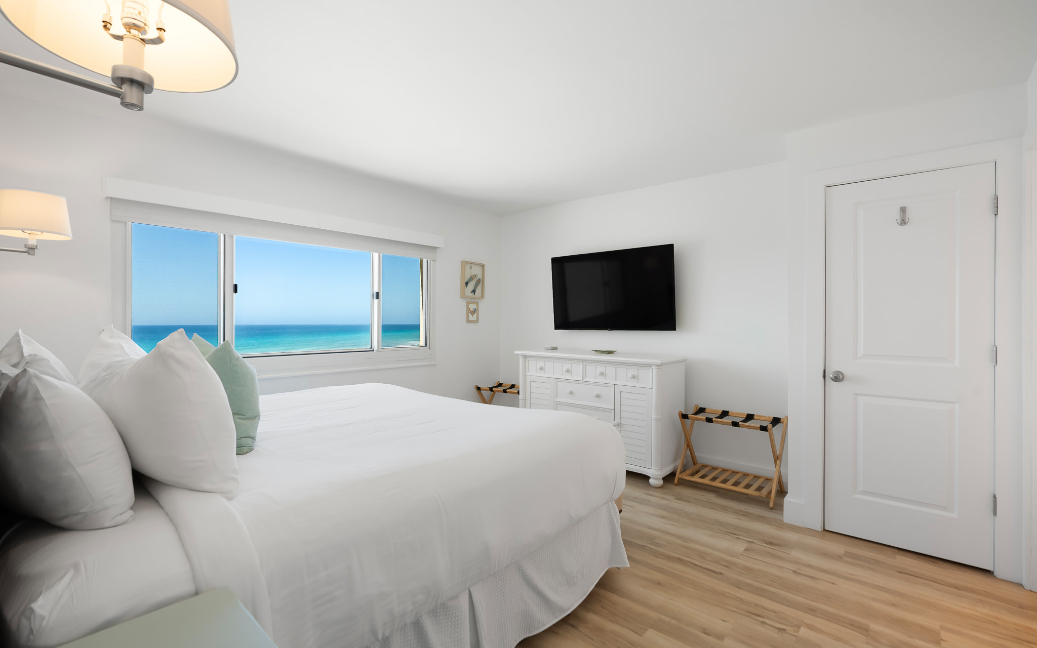Wake up to breathtaking gulf views from your serene bedroom sanctuary, where white linens and coastal breezes create the perfect retreat.