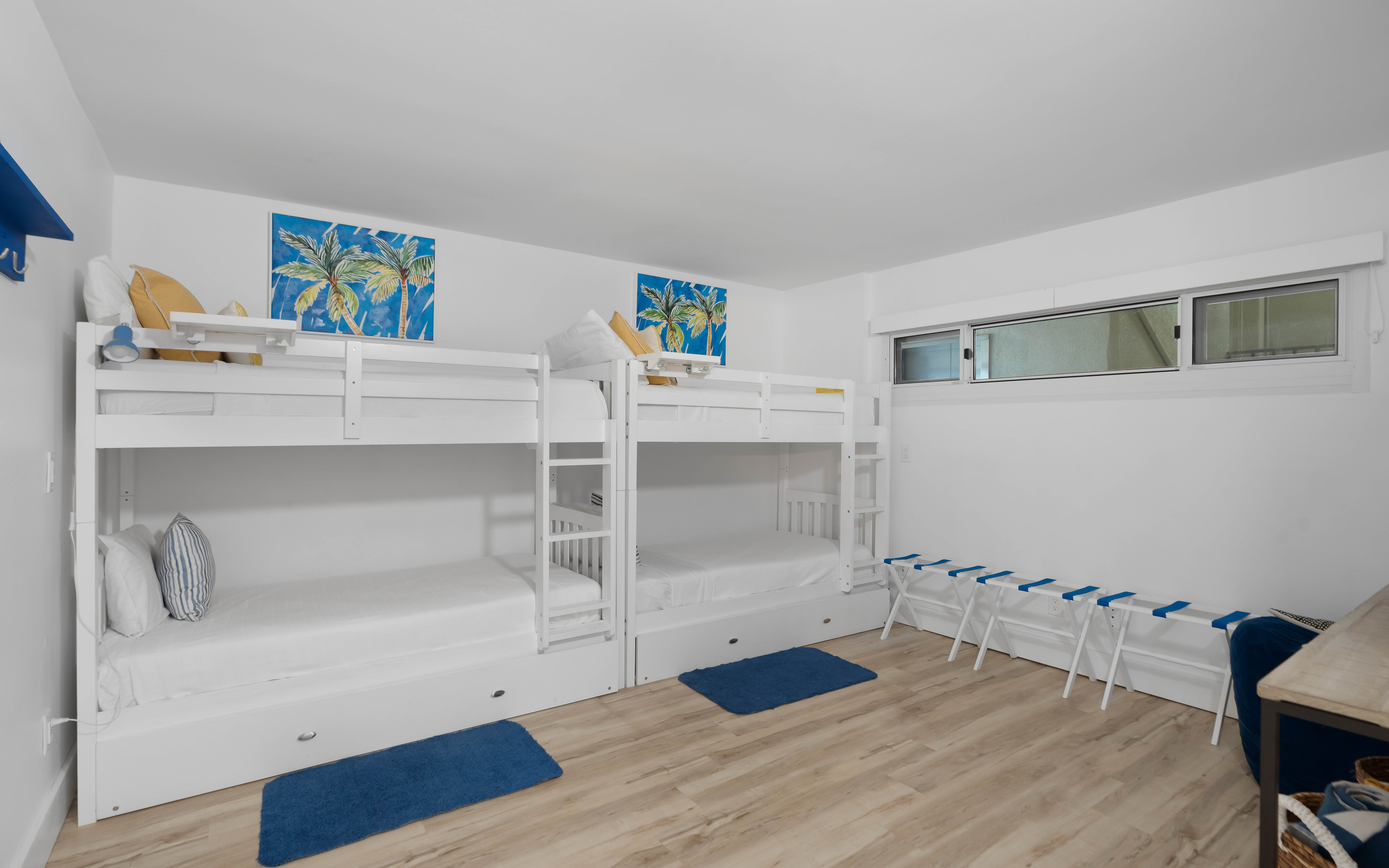 Your family will love this cheerful bunk room with crisp white beds, tropical artwork, and plenty of space for luggage storage.