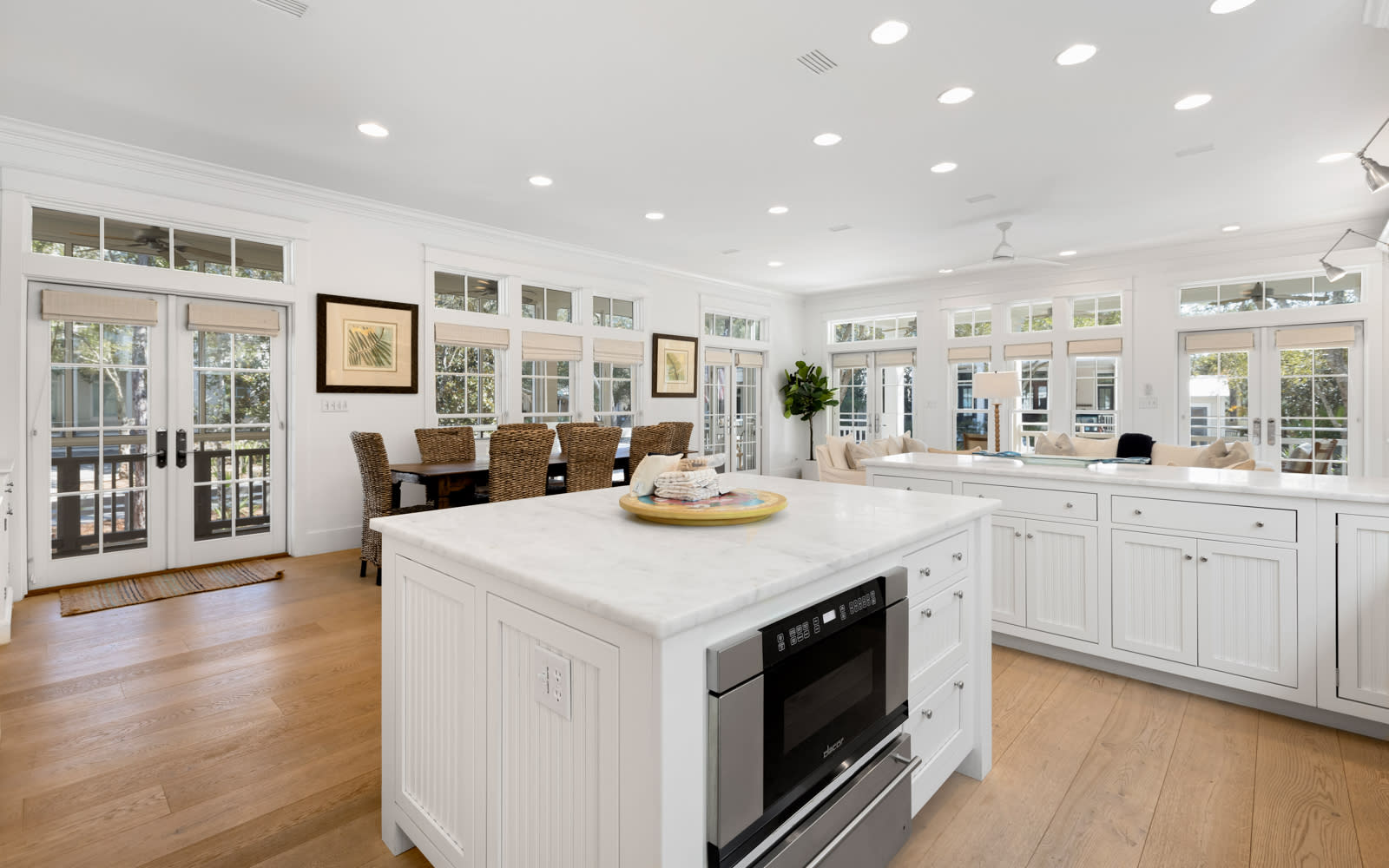 Gather around your bright kitchen island for meals and conversation, surrounded by sun-filled windows and elegant white cabinetry.