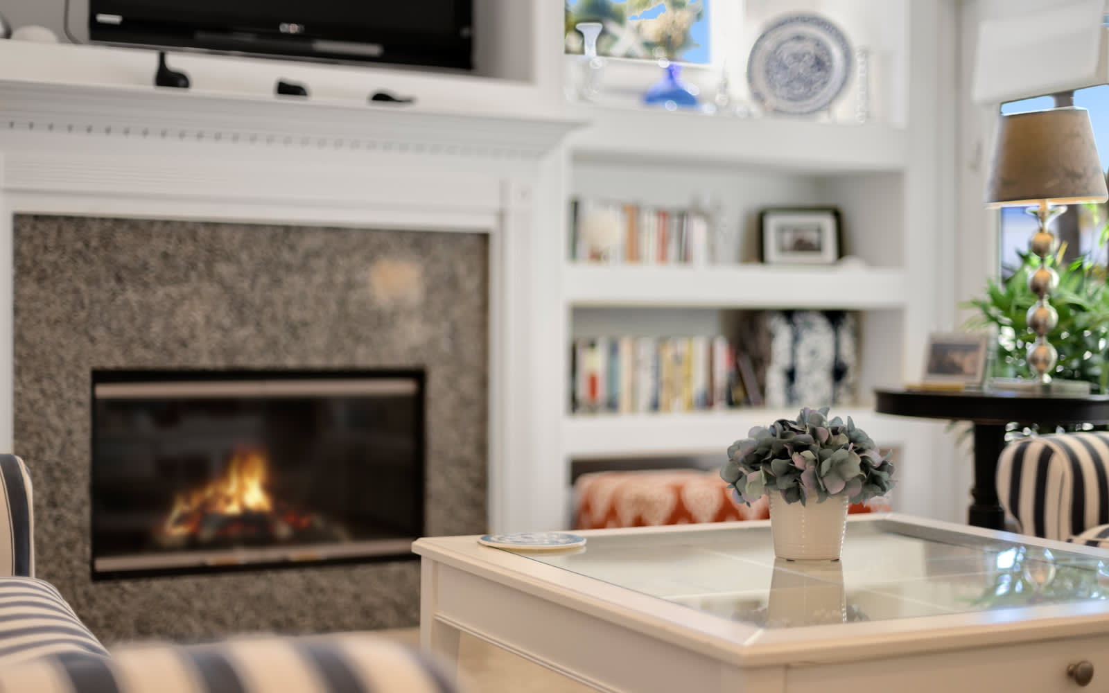 Curl up in this cozy living room where crackling flames and built-in bookshelves create your perfect reading retreat.