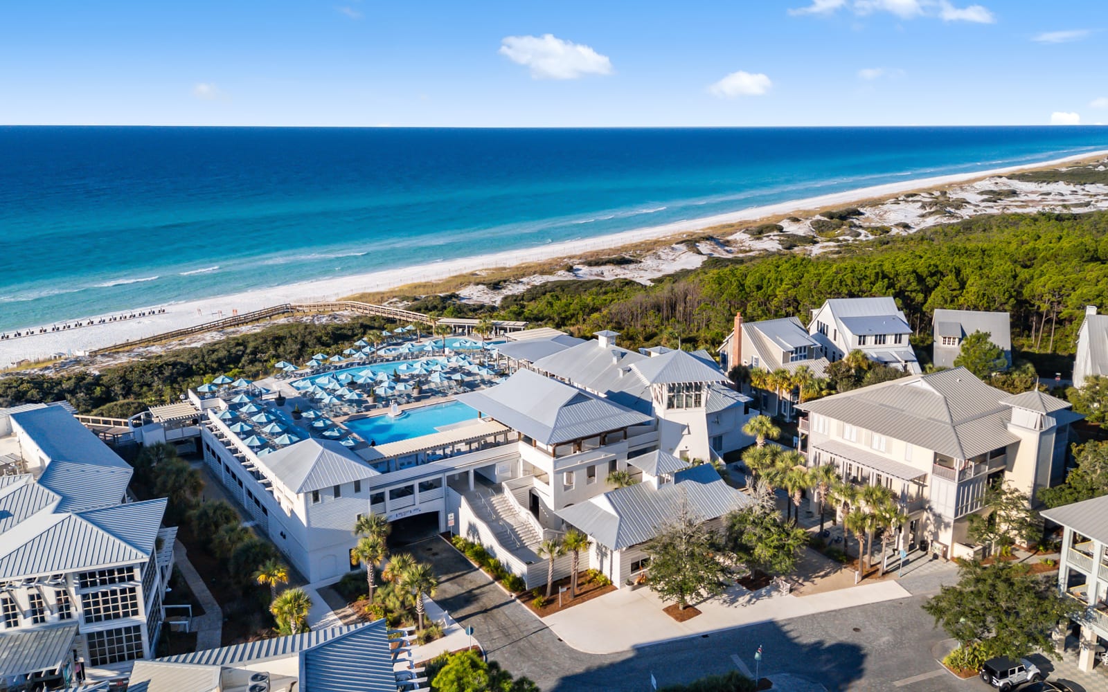 Stunning beachfront resort featuring pristine white sand beaches, crystal blue waters, and elegant coastal architecture surrounded by lush tropical vegetation.