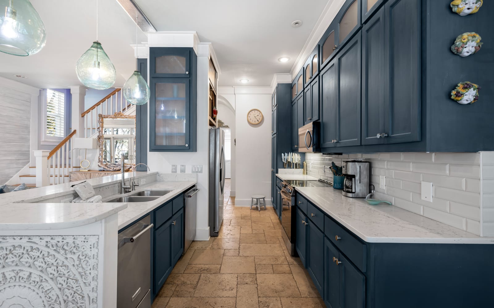 Your spacious galley kitchen features rich navy cabinets, marble countertops, and stainless appliances—perfect for preparing memorable meals together.