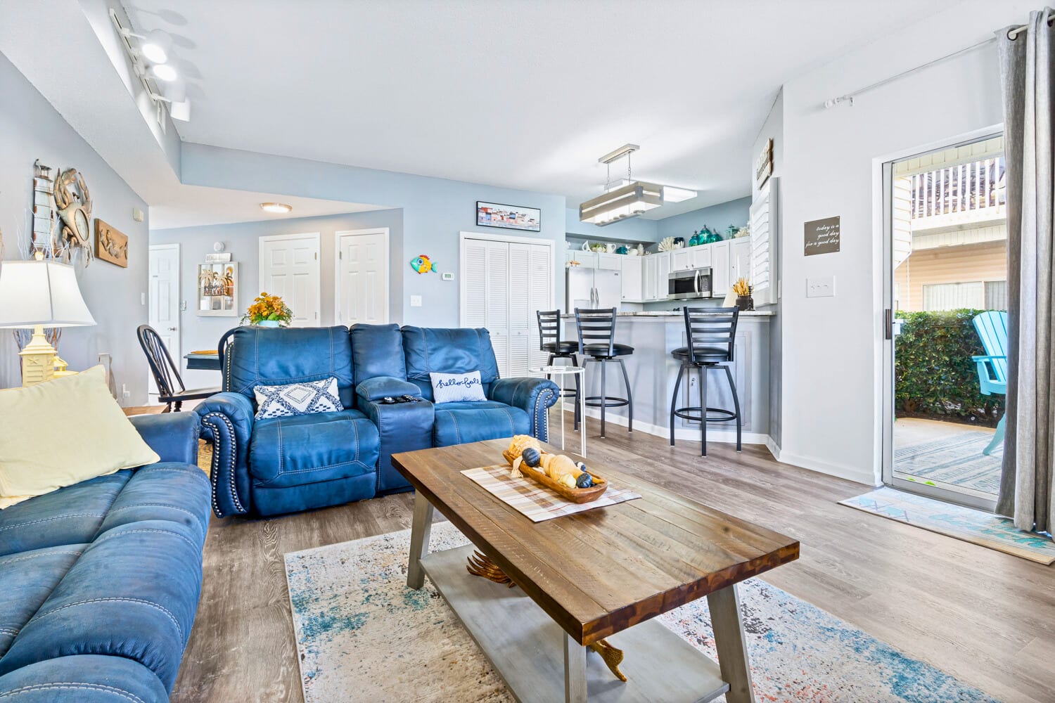 Relax in your bright, open-concept space with plush blue leather seating and modern kitchen access.