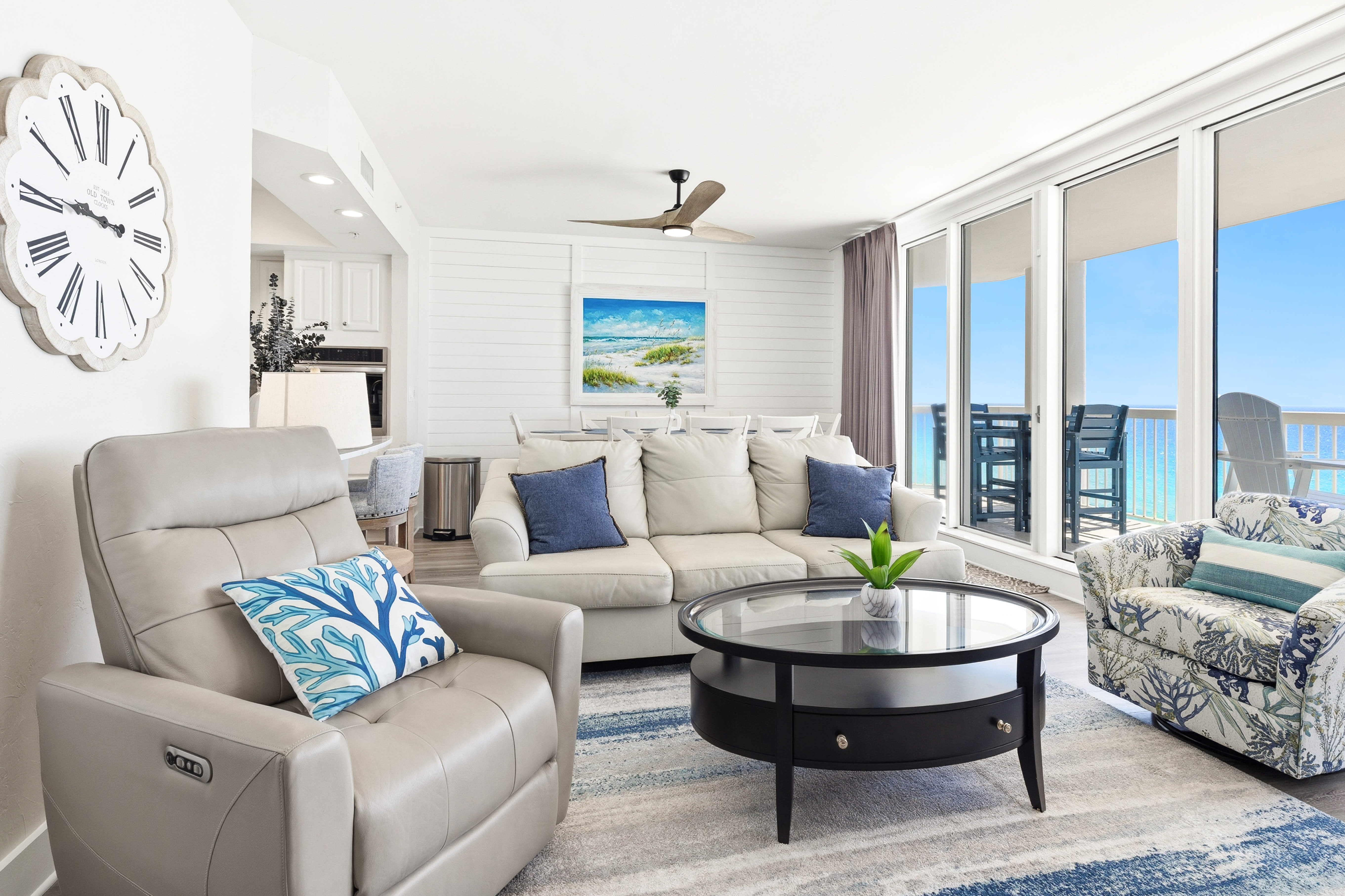 Relax in your bright living space with comfortable seating and stunning ocean views through floor-to-ceiling windows.