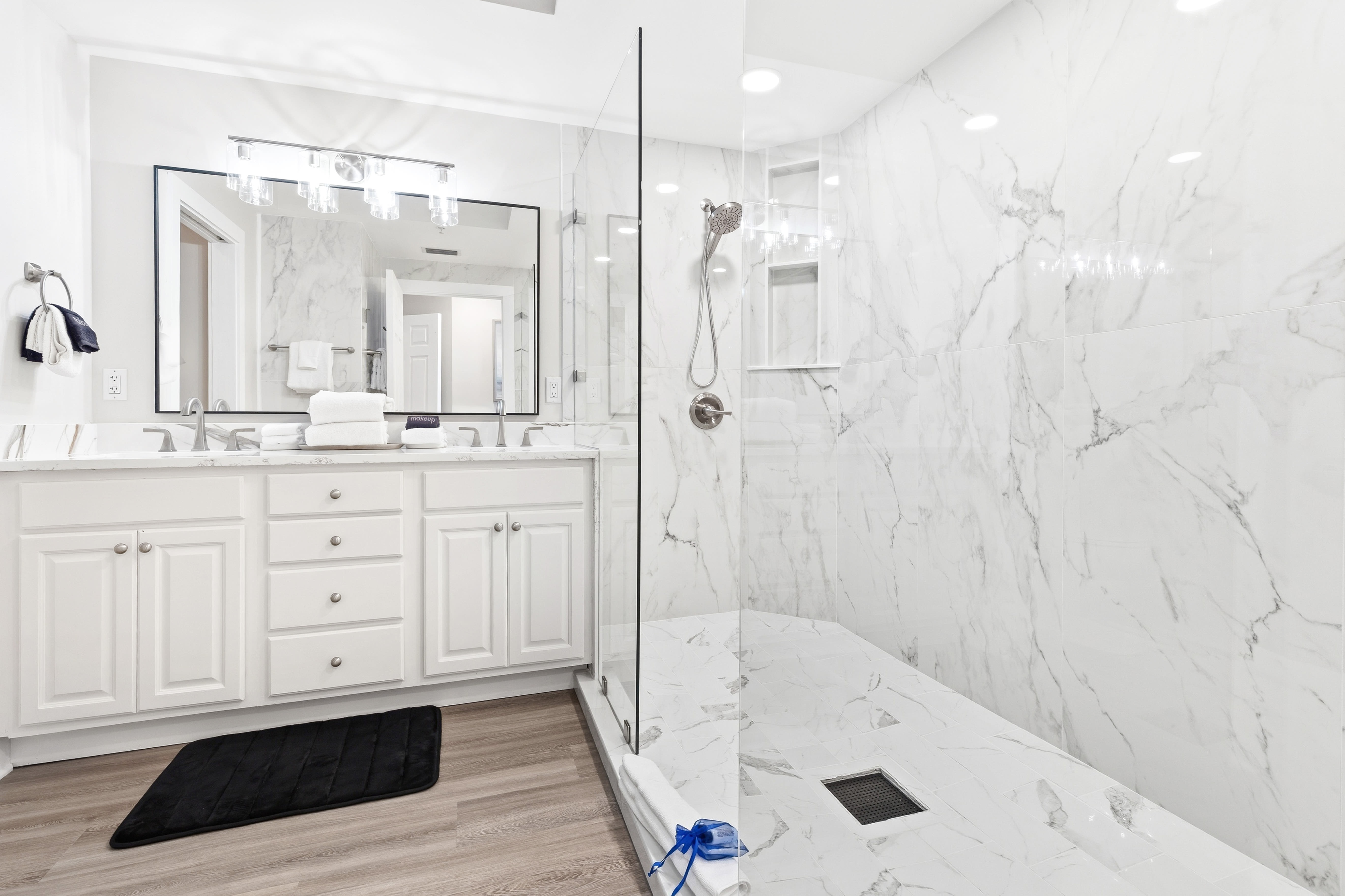 Luxurious marble bathroom with spacious walk-in shower and elegant vanity awaits your morning routine.