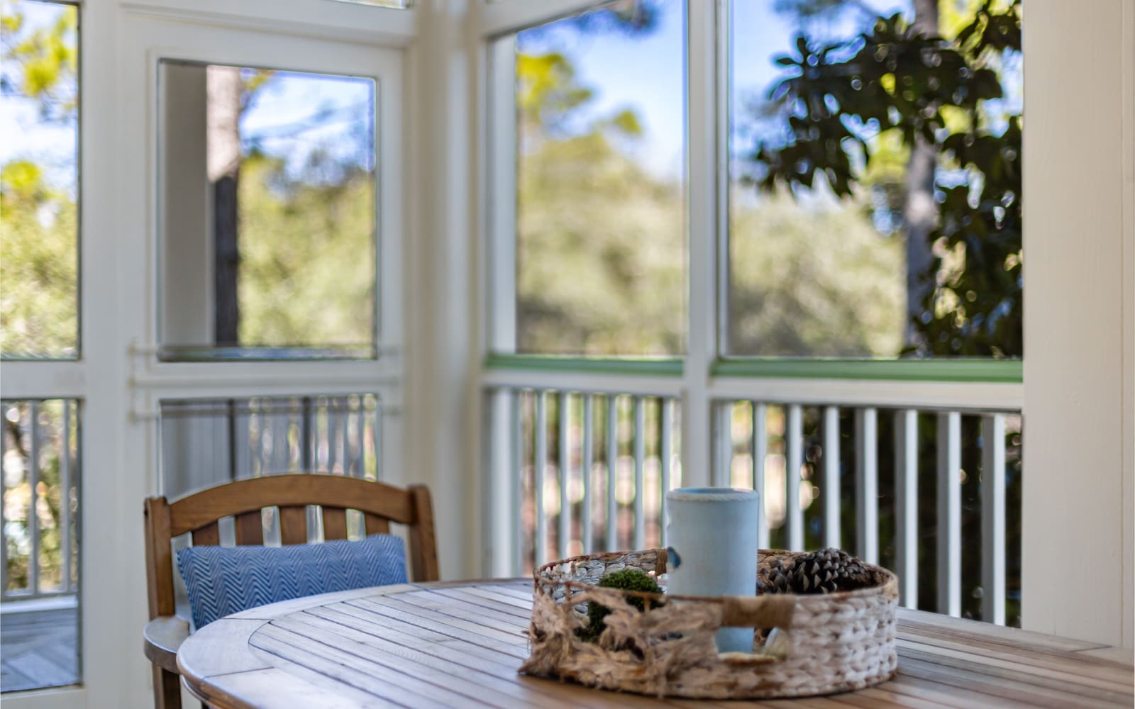 Your bright dining nook overlooks lush greenery through floor-to-ceiling windows, creating a peaceful breakfast spot bathed in natural light.