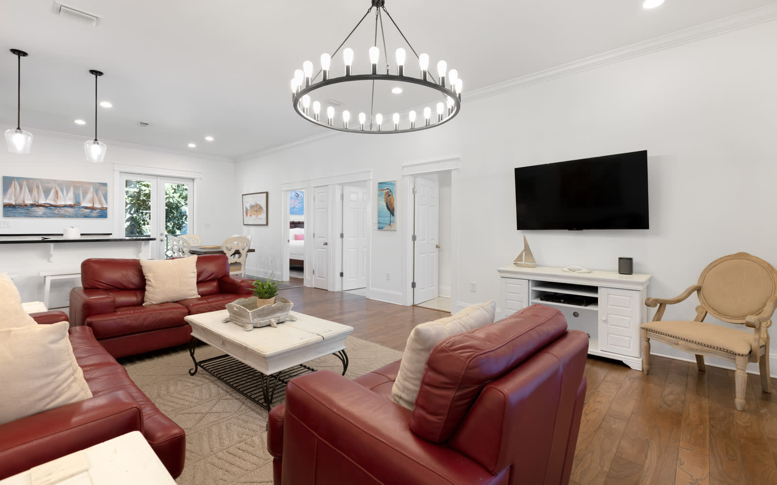 Sink into plush leather seating beneath an elegant chandelier in your spacious living area, perfect for cozy movie nights.