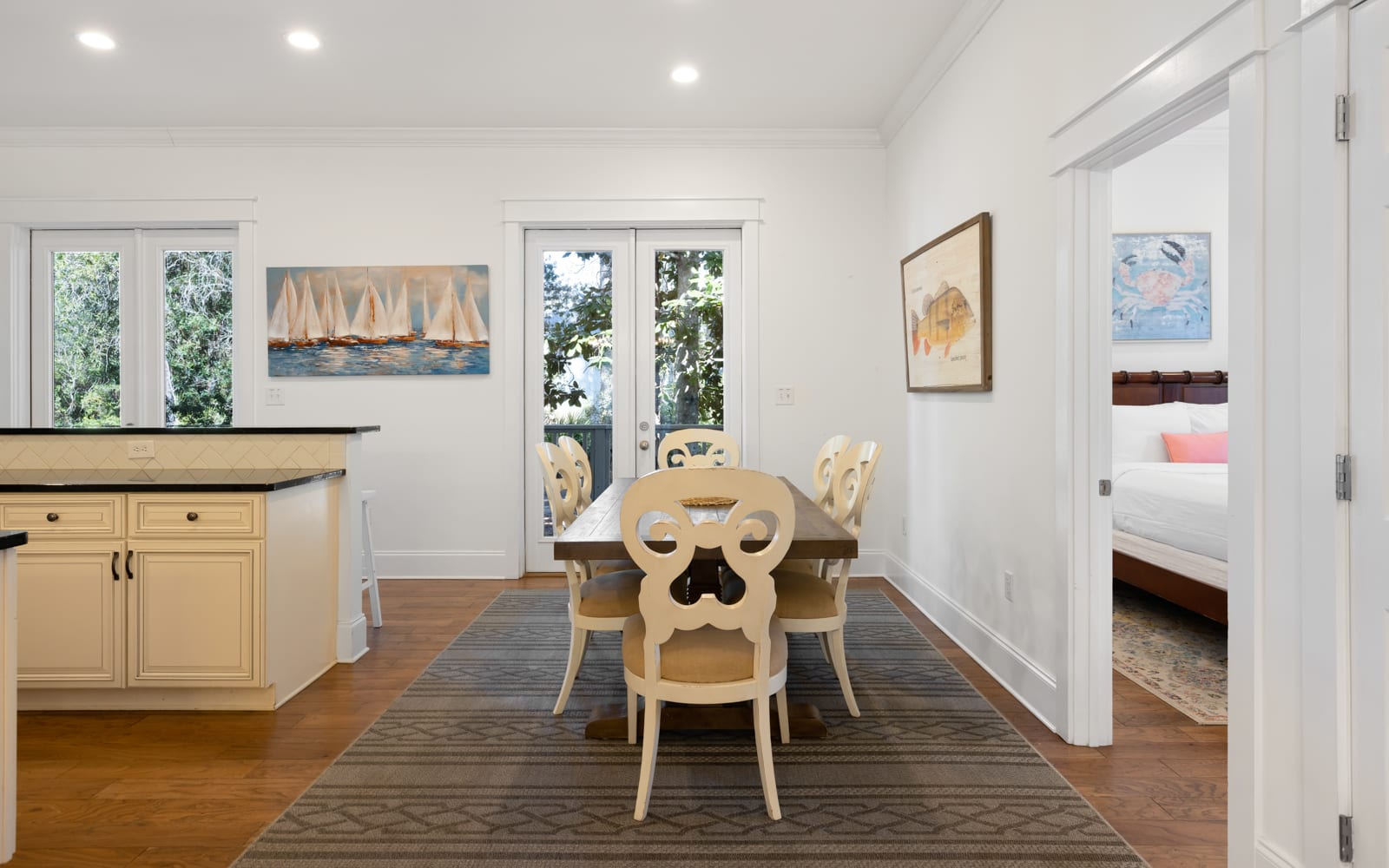 Gather around this elegant dining table where meaningful conversations flow as easily as your morning coffee, with natural light streaming through French doors.