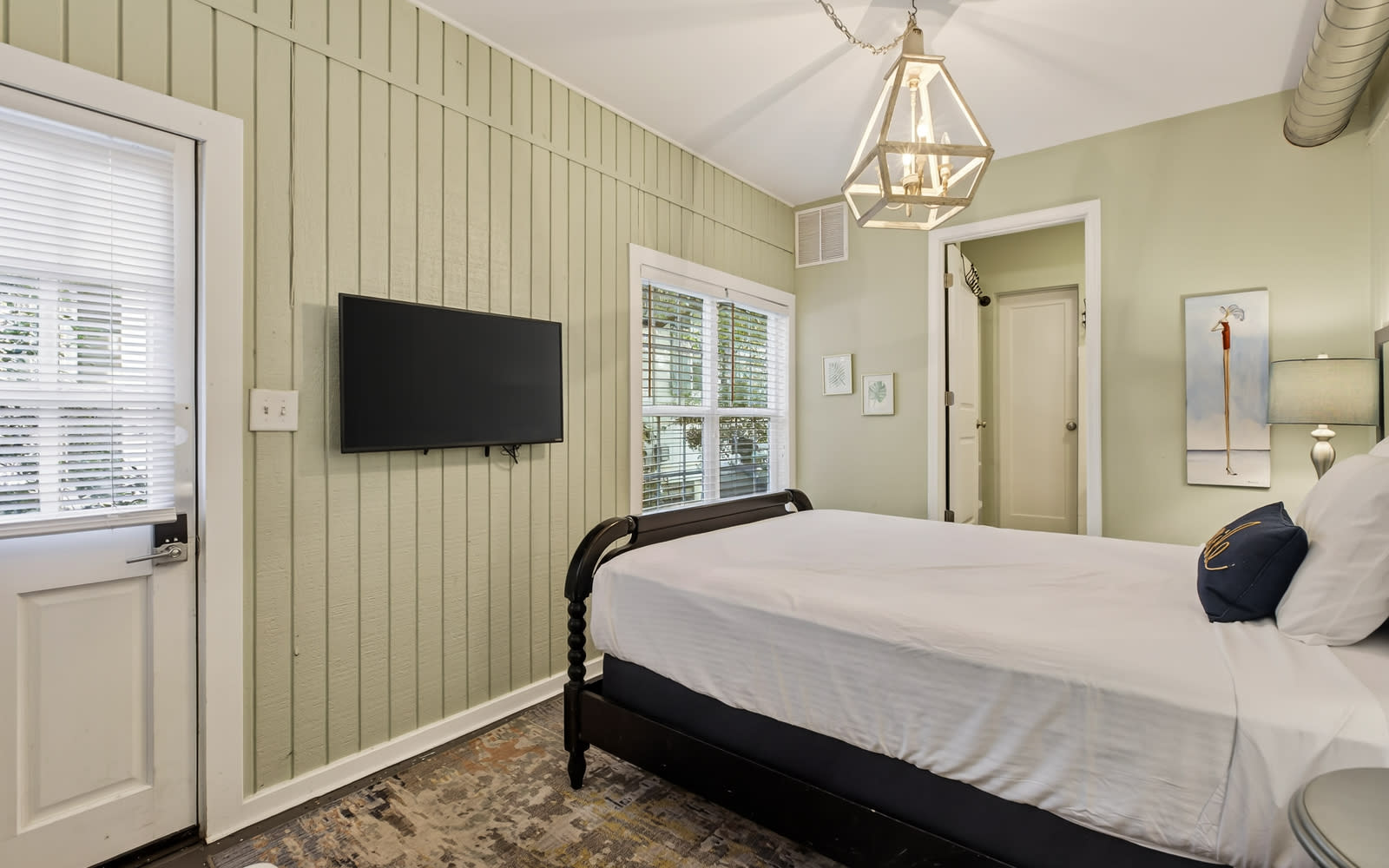 Settle into this charming bedroom with crisp linens, soothing green walls, and modern amenities for your perfect night's rest.