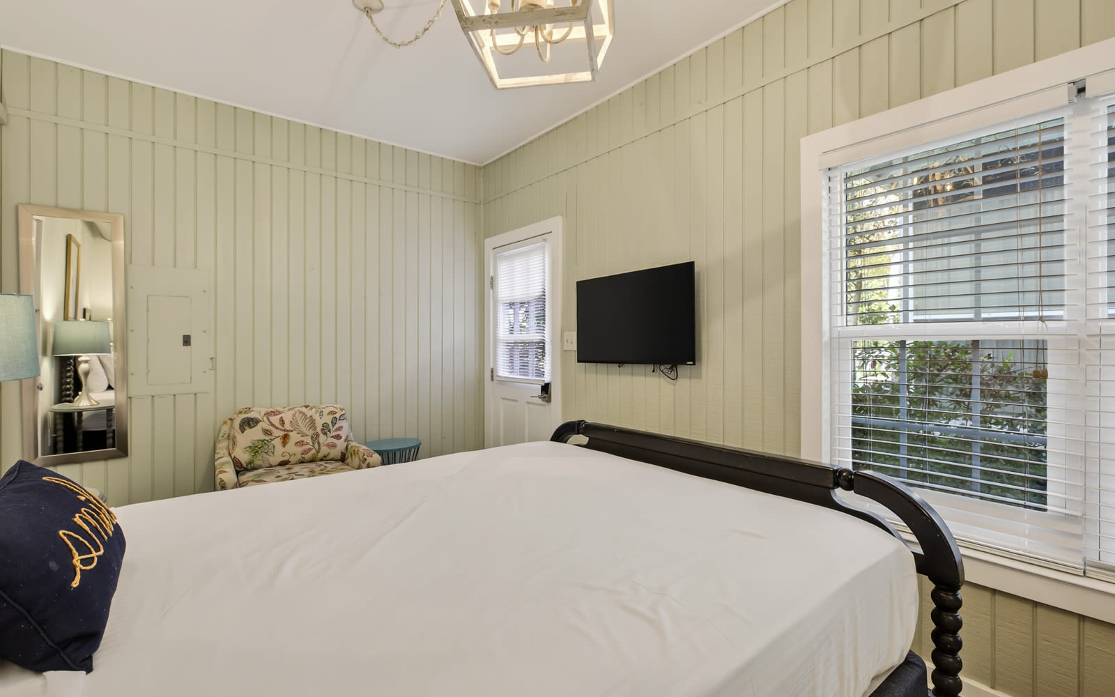 Sink into crisp white linens in your charming bedroom, where soft green walls and natural light create the perfect retreat.