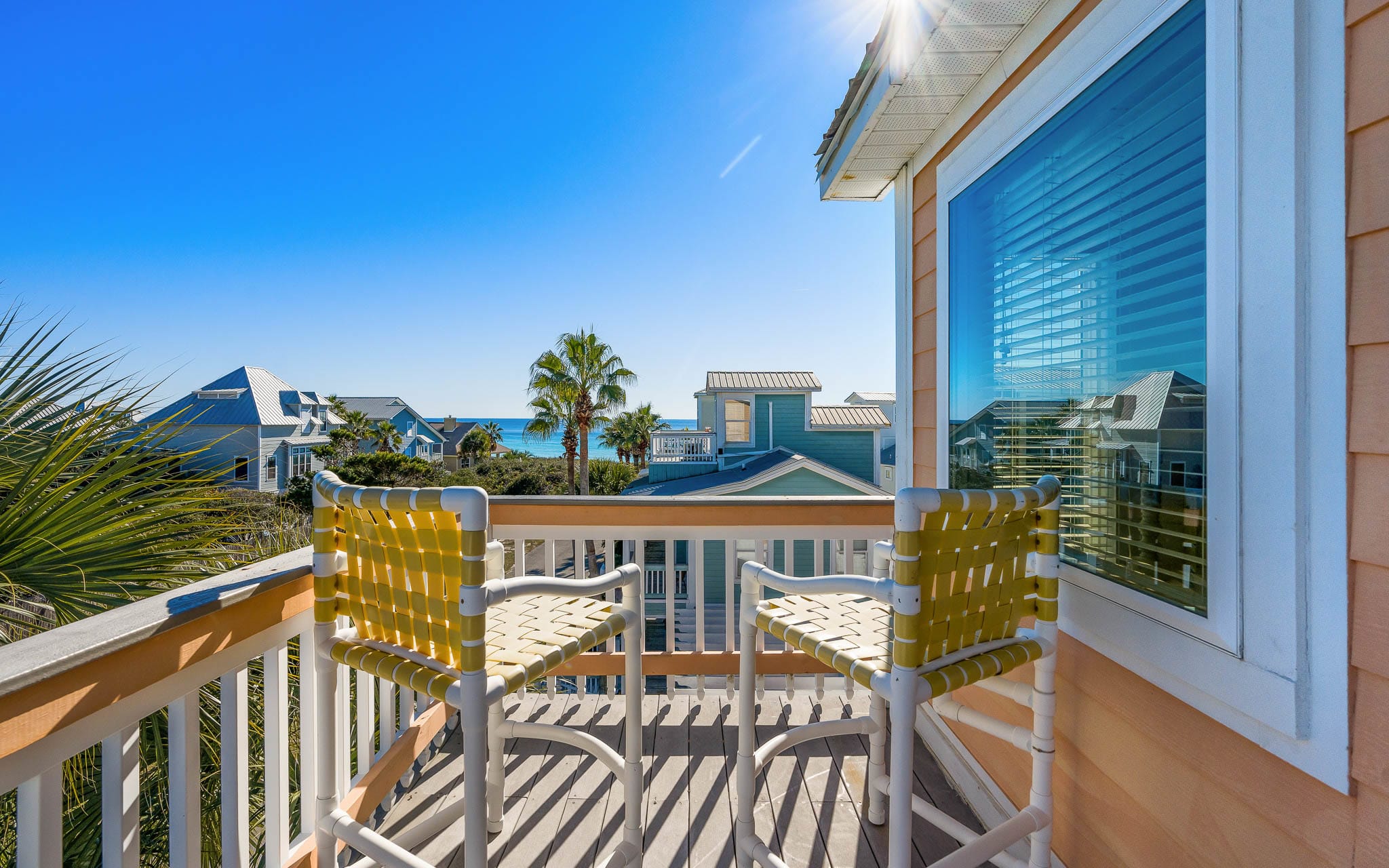 Bright yellow chairs await on your private balcony, perfect for morning coffee while soaking up coastal views and gentle gulf breezes.