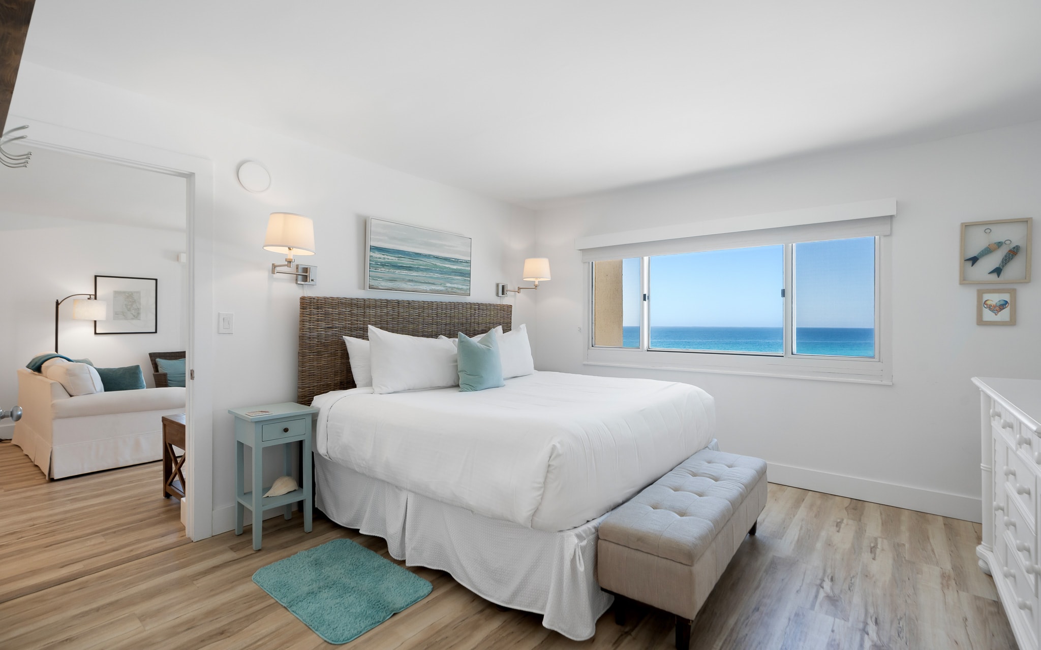 Wake up to stunning ocean views through your bedroom window, where crisp white linens and coastal decor create the perfect seaside retreat.