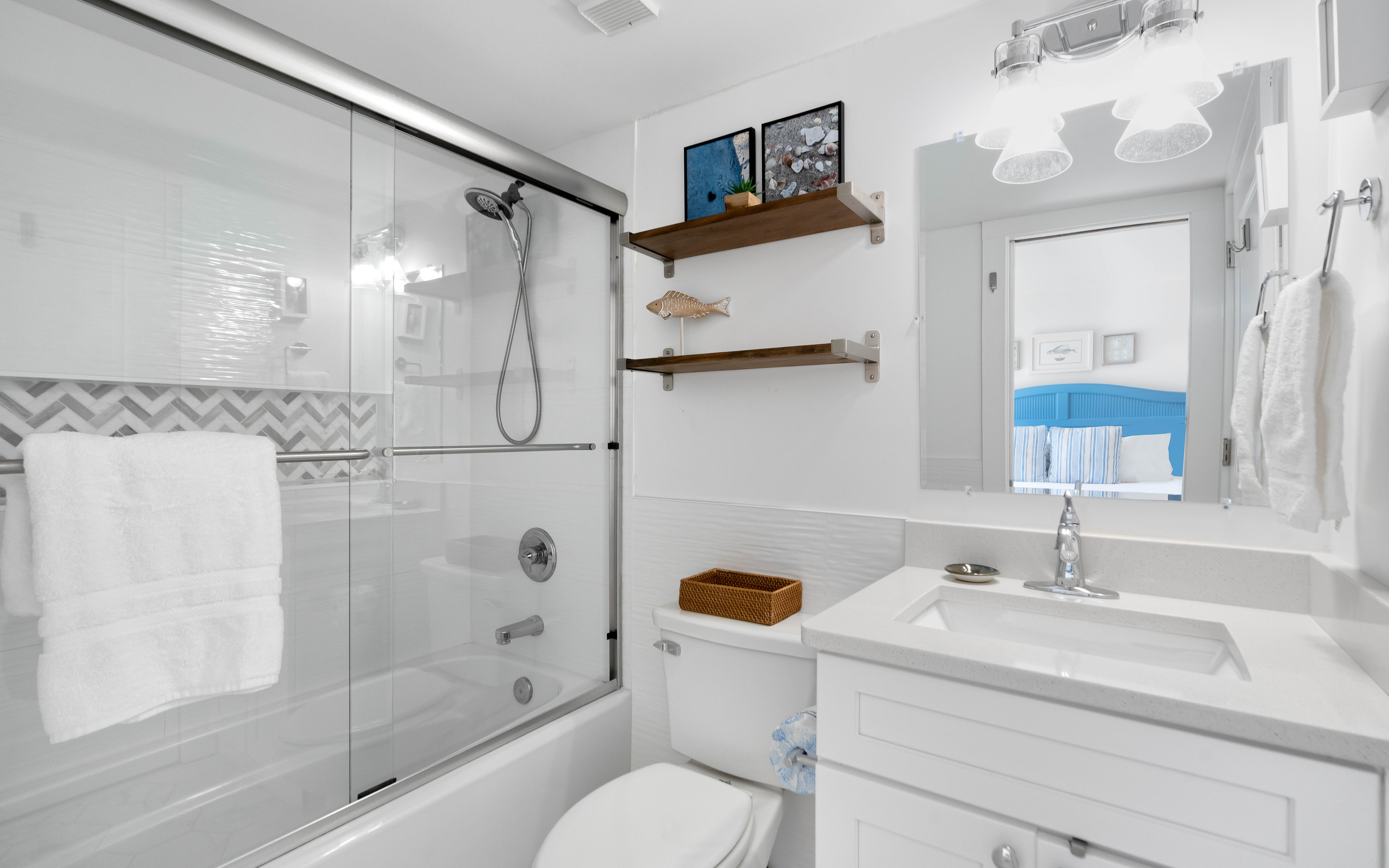 Unwind in your pristine bathroom featuring a luxurious soaking tub, refreshing walk-in shower, and thoughtful coastal touches that make every moment feel like a spa retreat.