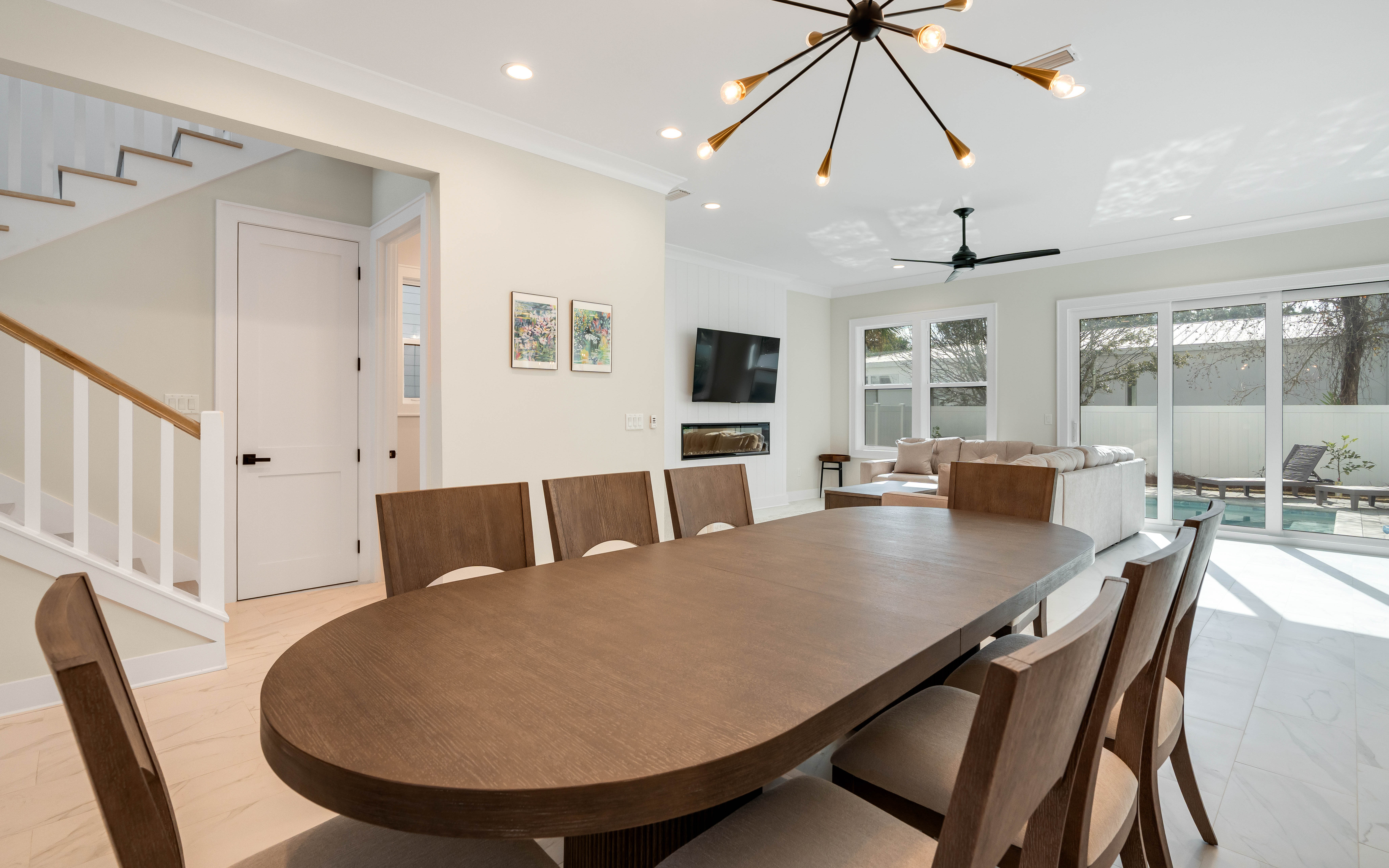 Gather around this elegant dining table where memorable meals await, while natural light streams through floor-to-ceiling windows.