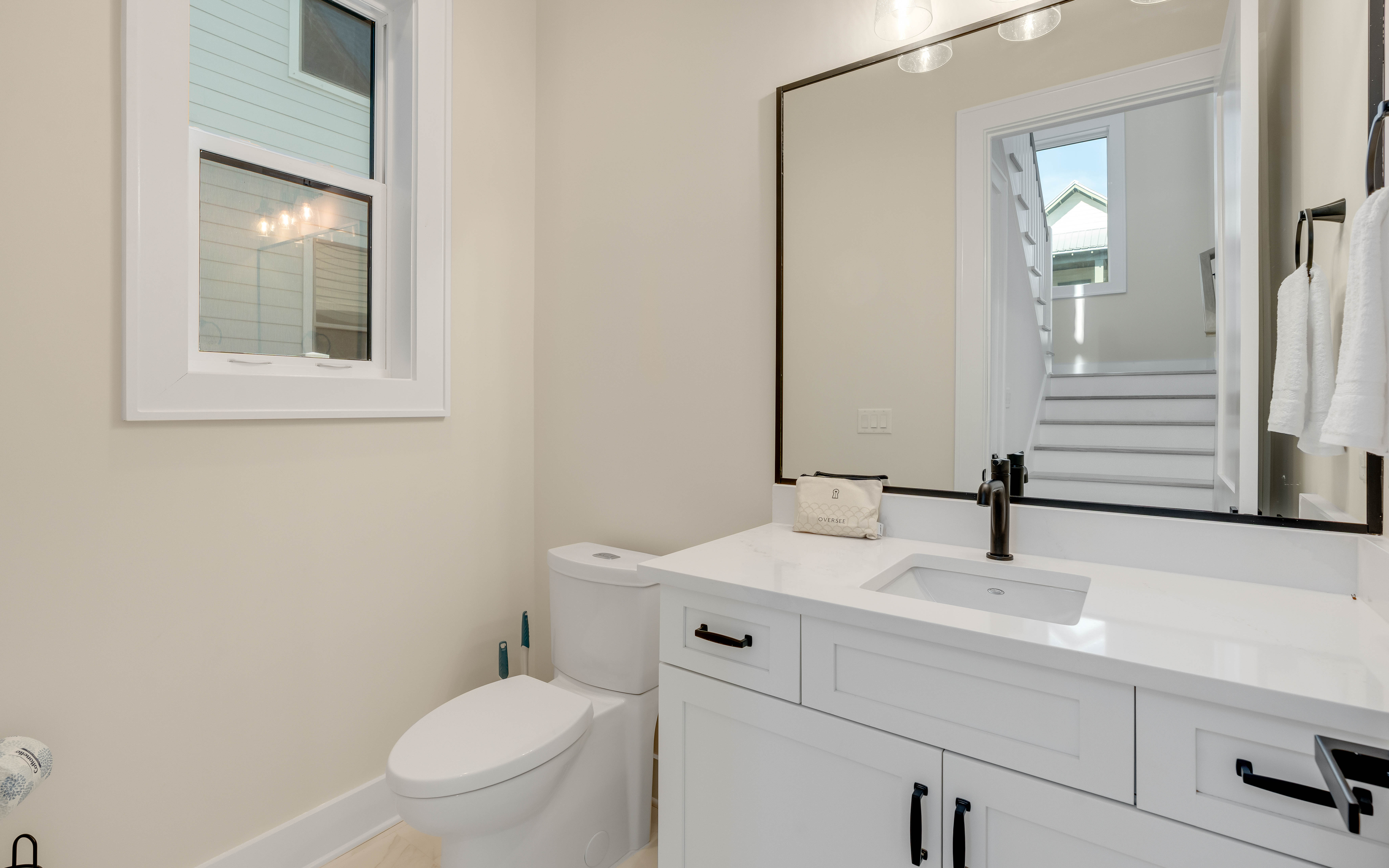 Your private bathroom features clean white vanity, stylish fixtures, and natural light from the window.
