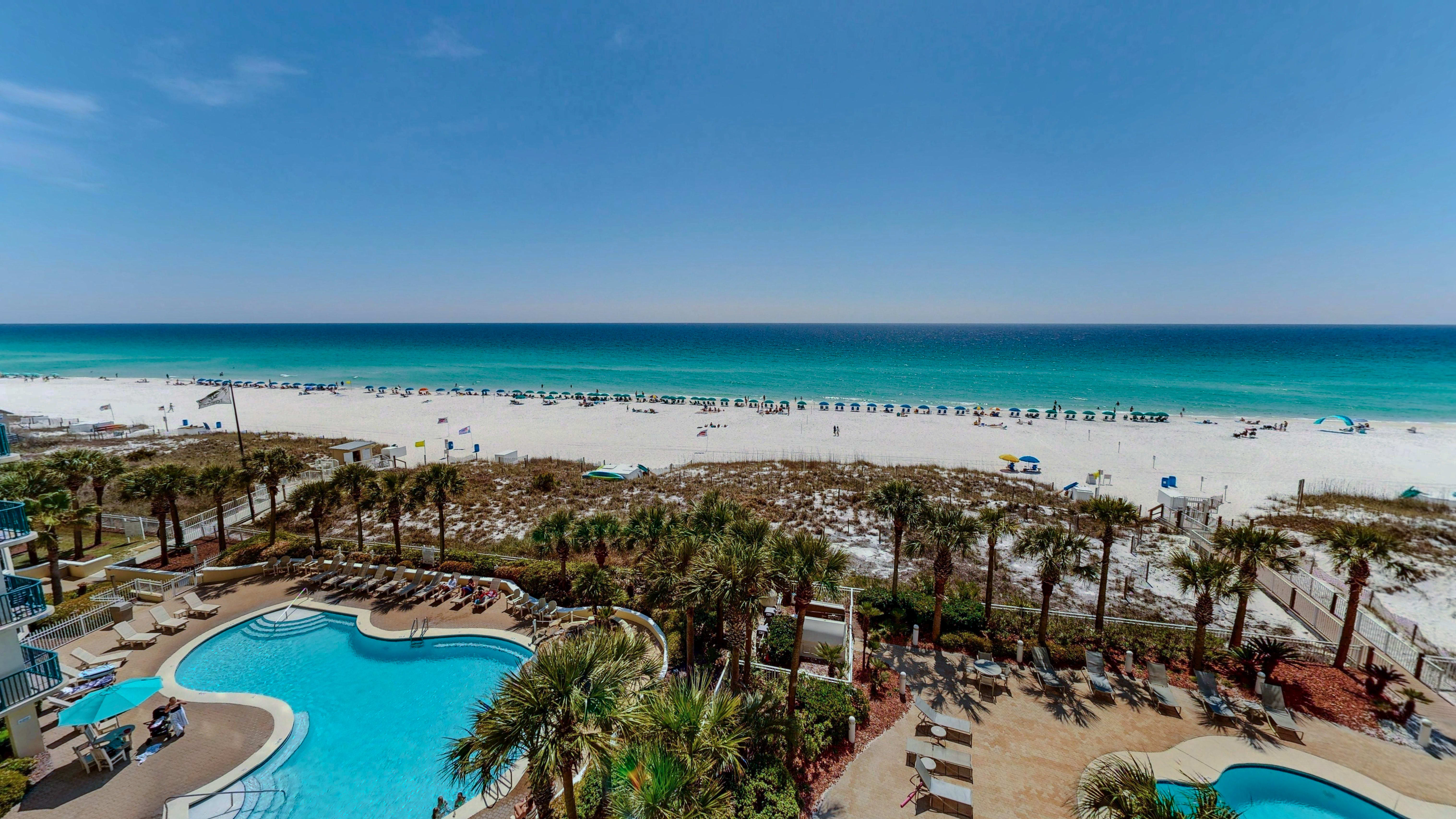 Beachfront property featuring pools and direct access to pristine white sand beach with turquoise waters.