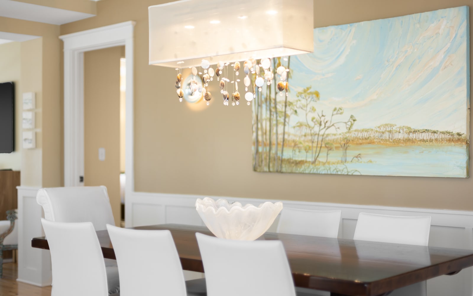 Gather around your elegant dining table where thoughtful touches and beautiful artwork create the perfect atmosphere for memorable meals together.