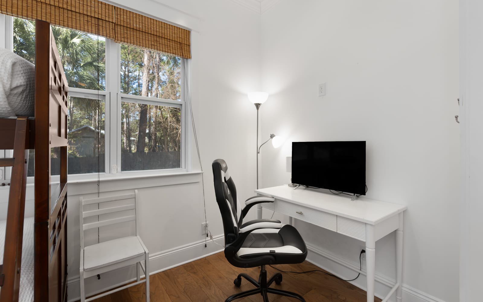 Your bright workspace features a sleek desk, comfortable chair, and TV - perfect for remote work with peaceful garden views.
