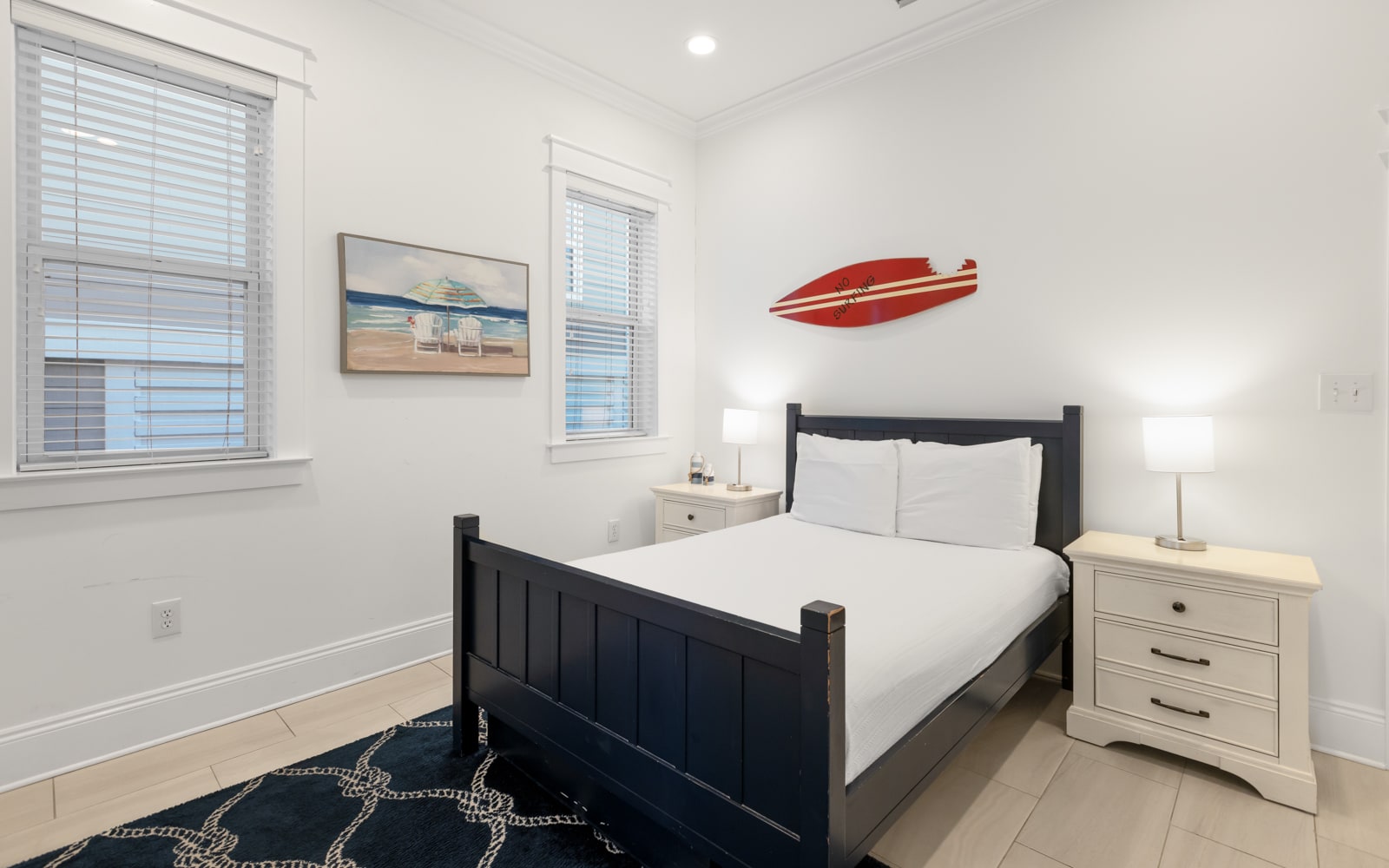 Rest easy in your coastal bedroom with crisp white linens and cheerful surf-themed decor that captures beachside charm.