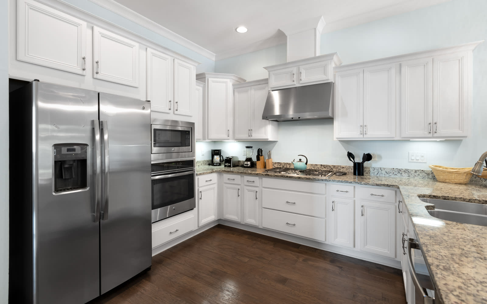Your fully-equipped kitchen features gleaming granite counters, stainless steel appliances, and pristine white cabinetry—perfect for preparing memorable meals during your stay.