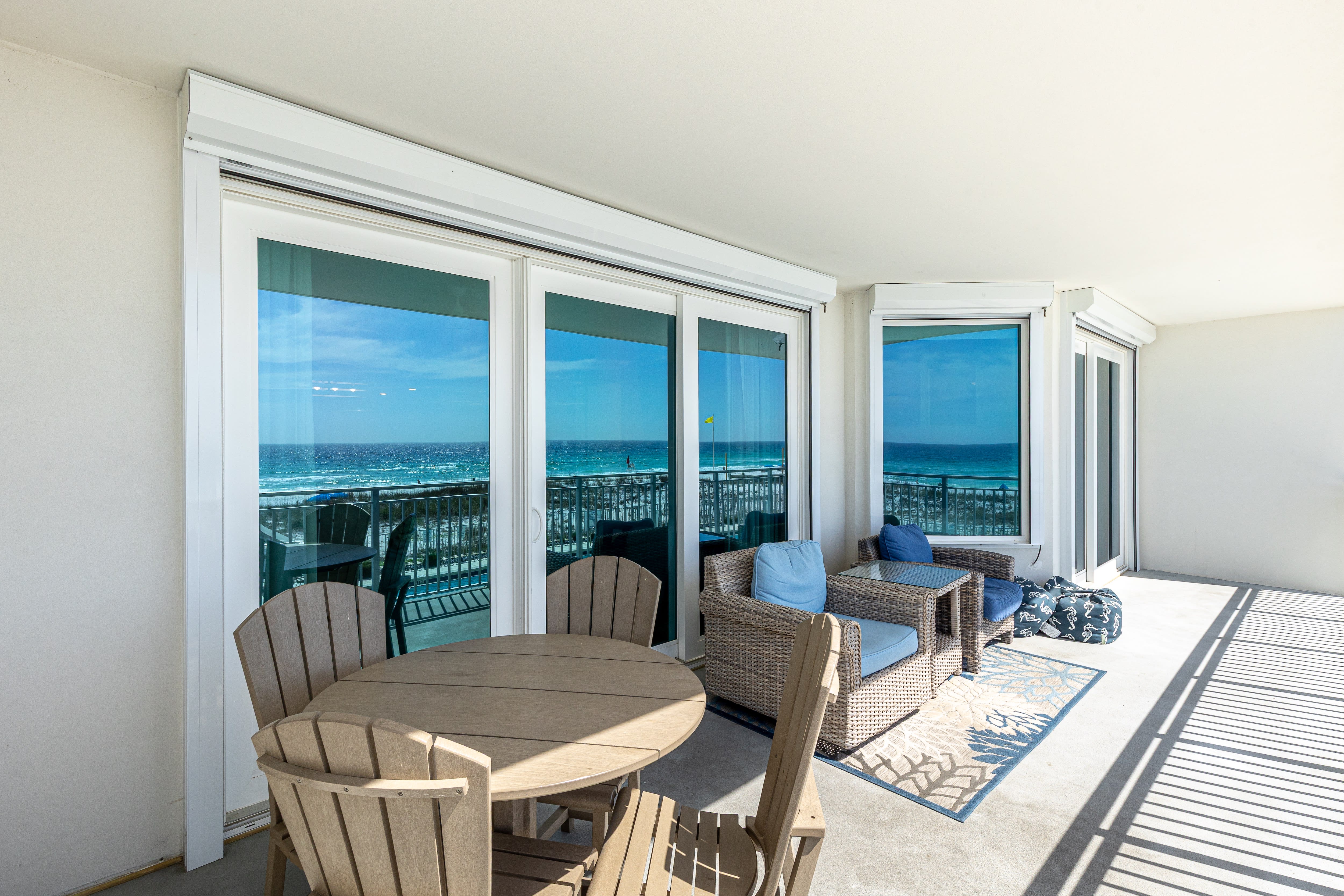 Your private covered terrace opens to stunning ocean views, complete with dining table and lounge seating for seaside relaxation.