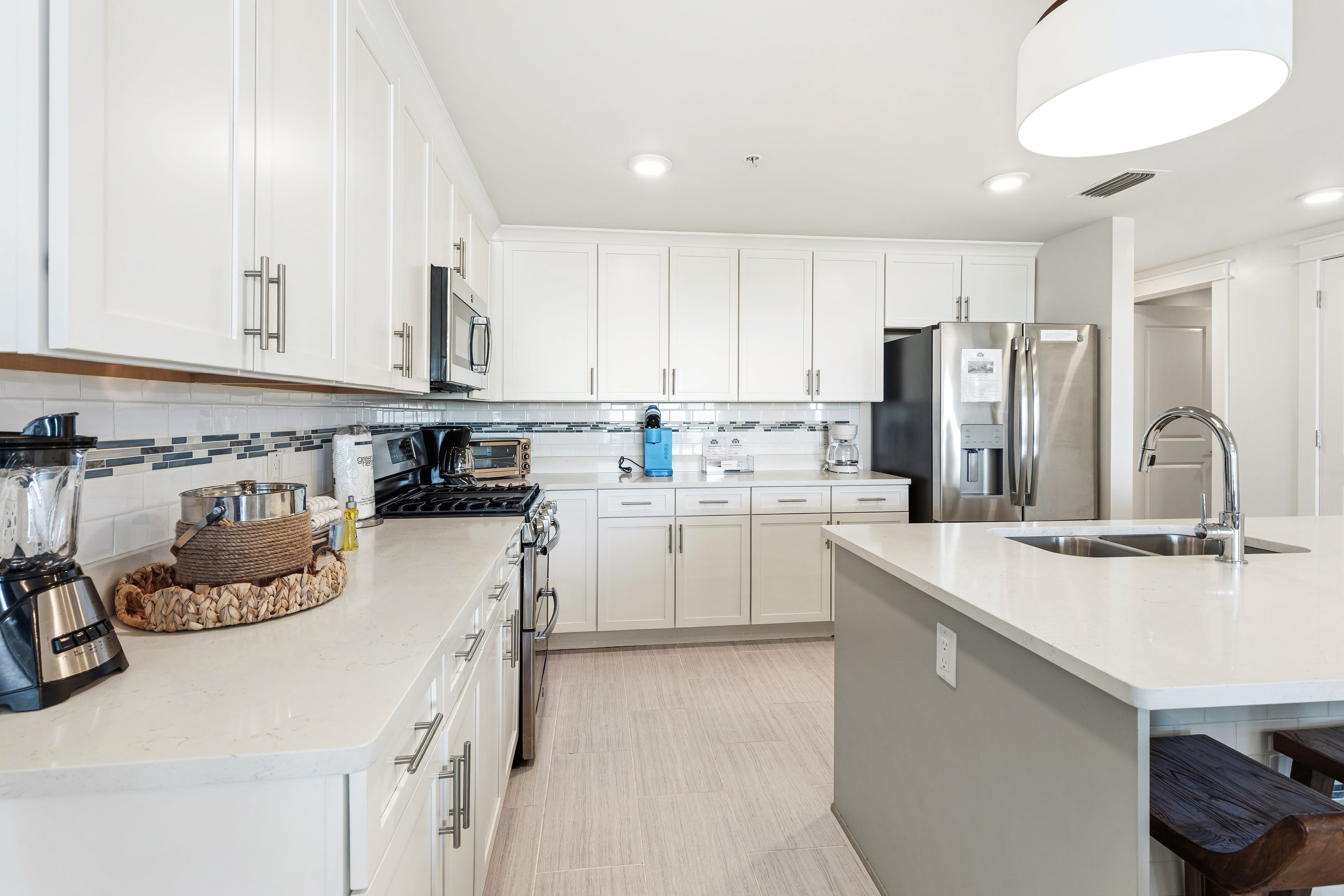 Your spacious kitchen awaits with gleaming white cabinets, stainless steel appliances, and ample counter space for cooking memorable vacation meals.