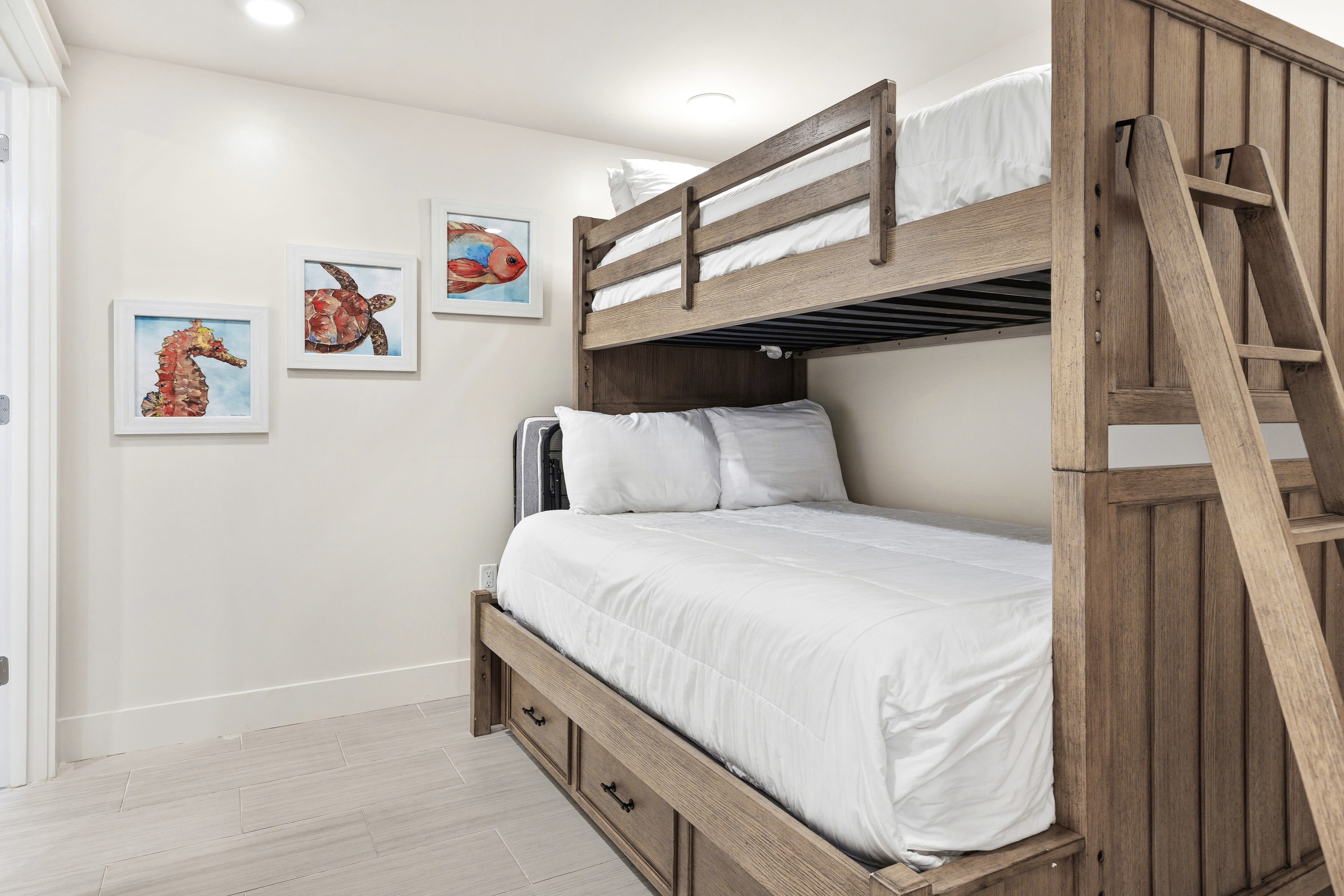 Your kids will love this cozy bunk room with whimsical sea creature art and plenty of space to dream.